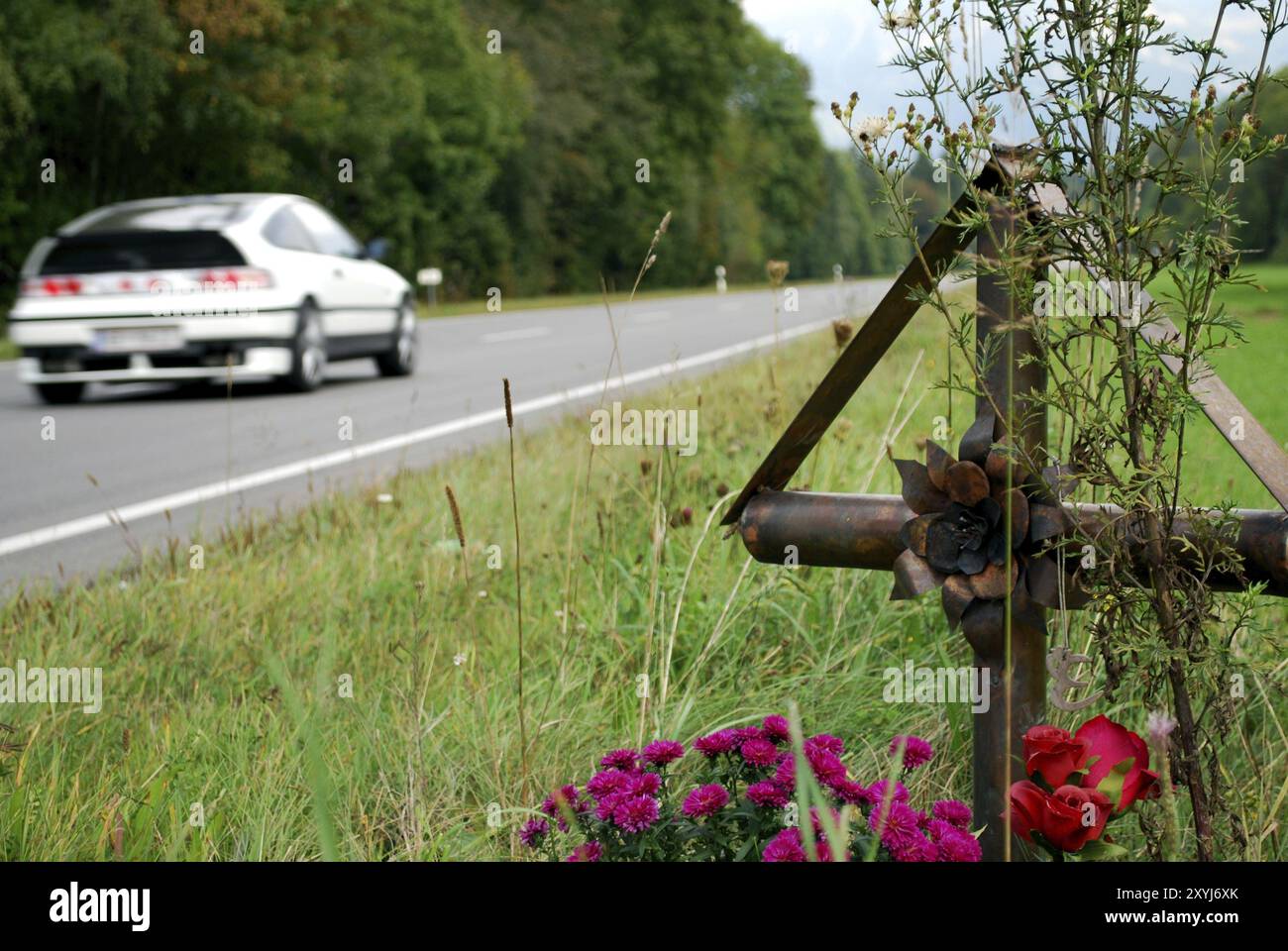 Croix de fleurs sur le bord d'une route de campagne pour le mémorial des nombreuses victimes d'accidents Banque D'Images