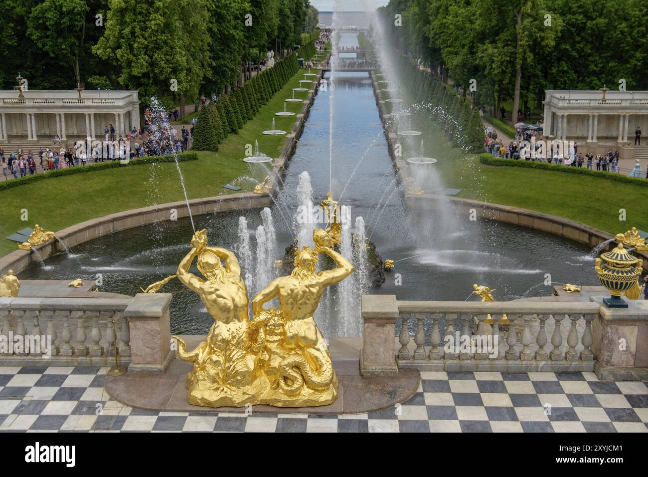 Magnifique fontaine de jardin avec sculptures dorées et jet d'eau montant, en arrière-plan se promenant les gens et les espaces verts, saint-pétersbourg, baltique Banque D'Images