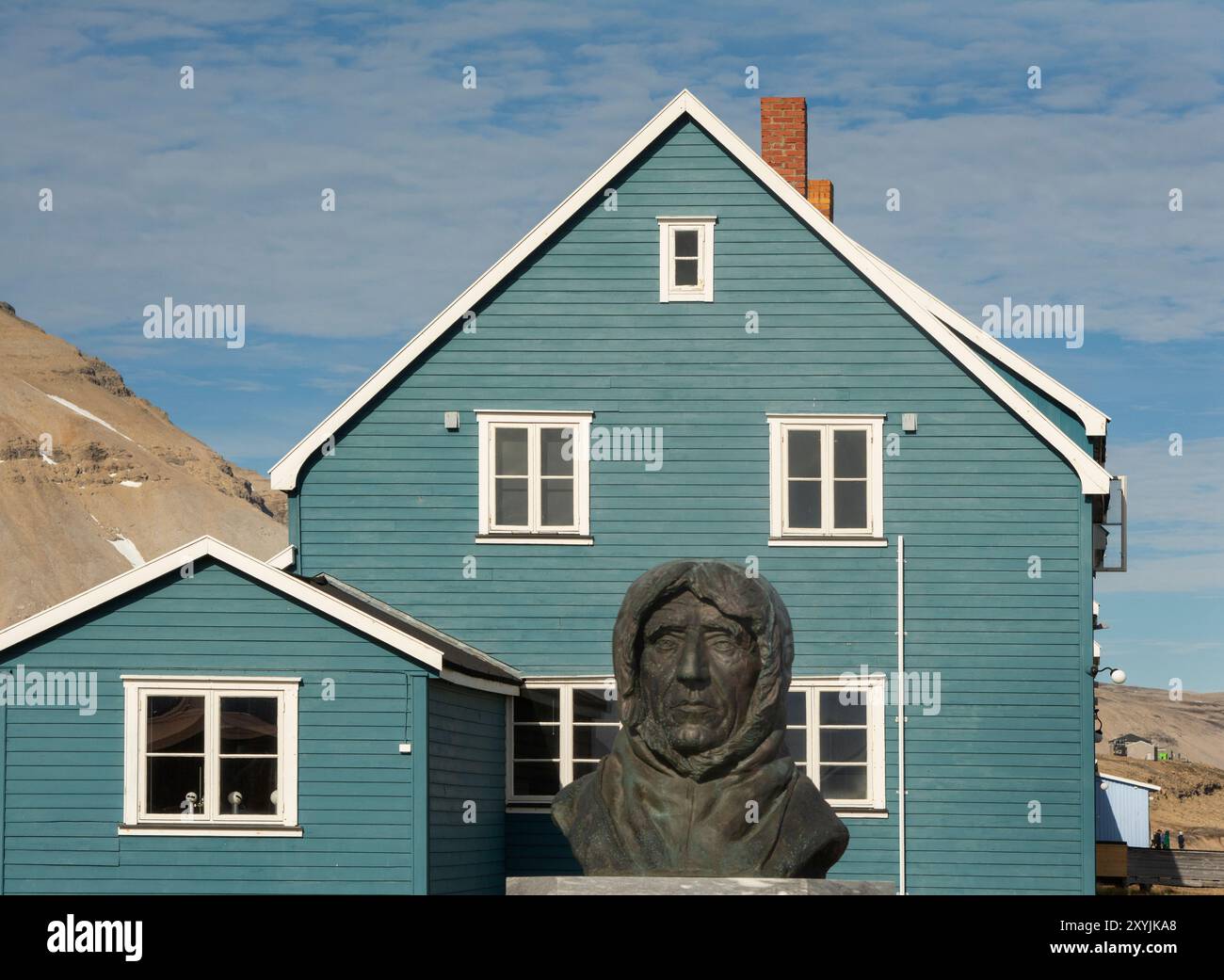 Statue de Roald Amundsen avec logement typique à l'arrière, NY-Alesund (NY-Ålesund), Oscar II Land, Svalbard, Norvège Banque D'Images