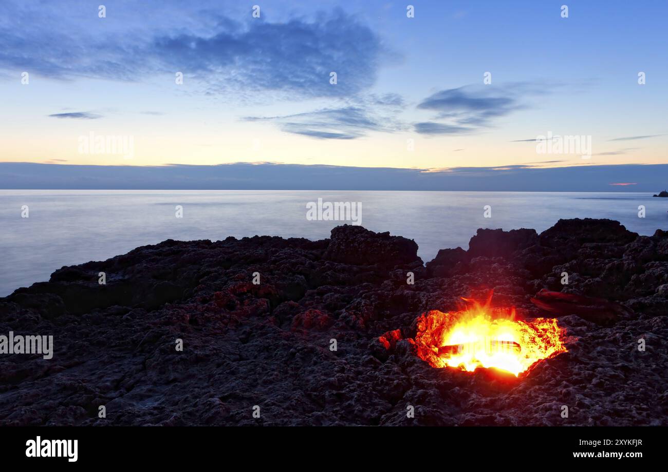 Petit feu de camp sur la côte rocheuse la nuit. Mer Noire, Crimée, Ukraine, Europe Banque D'Images