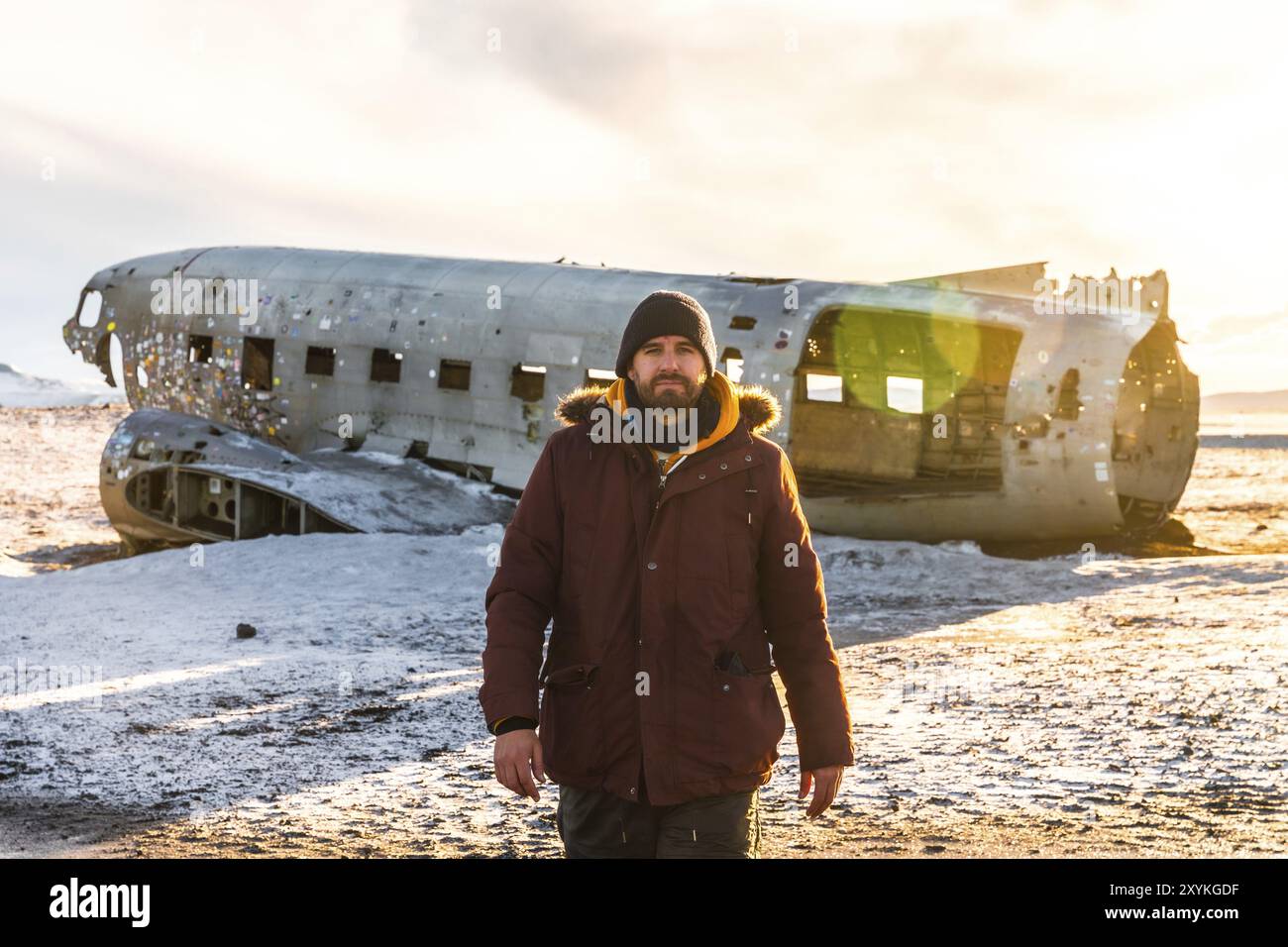 Un touriste marchant dans l'avion écrasé sur la plage gelée de Solheimasandur en hiver en Islande Banque D'Images