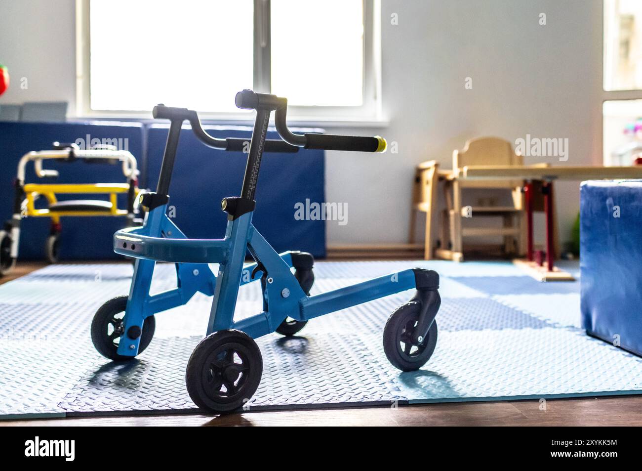 Marcheur coloré dans une salle de thérapie pour enfants, conçu pour engager des activités de réadaptation physique et de soutien Banque D'Images