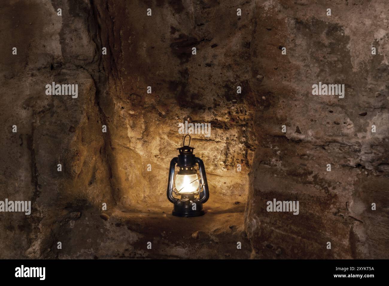 Une lampe à paraffine brûle dans la nuit sur un piédestal dans une ruine de vieux château sur des grès Banque D'Images