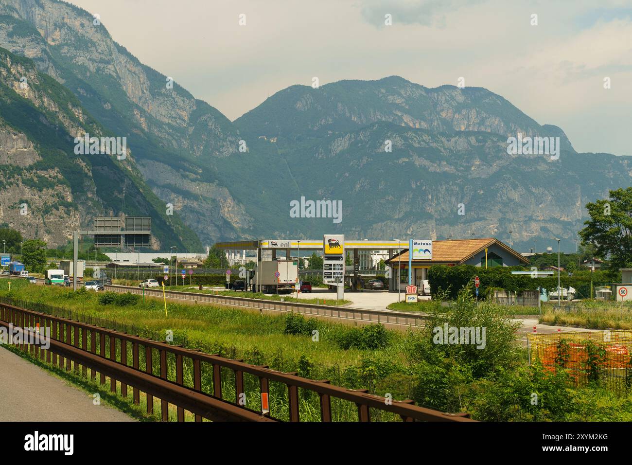 Trente, Italie - 8 juin 2023 : une station-service Eni avec un auvent et un petit magasin se trouve sur fond de montagnes majestueuses en Italie. Banque D'Images