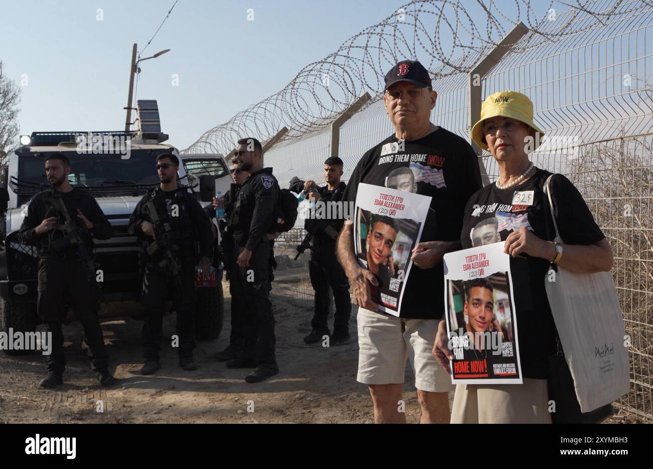 NIRIM, ISRAËL - AOÛT 29 : les grands-parents d'Edan Alexander, 19 ans, du 51e bataillon de la Brigade Golani qui est retenu en otage à Gaza, tiennent des affiches avec sa photo, tandis que les membres de la famille utilisent des haut-parleurs géants pour appeler leurs proches captifs près de la frontière avec la bande de Gaza le 29 août 2024 au Kibboutz Nirim, en Israël. Le Hamas a saisi environ 250 Israéliens et étrangers lors de ses attaques du 7 octobre contre le sud d’Israël, dont 108 sont toujours en captivité. Banque D'Images NIRIM, ISRAËL - AOÛT 29 : les grands-parents d'Edan Alexander, 19 ans, du 51e bataillon de la Brigade Golani qui est retenu en otage à Gaza, tiennent des affiches avec sa photo, tandis que les membres de la famille utilisent des haut-parleurs géants pour appeler leurs proches captifs près de la frontière avec la bande de Gaza le 29 août 2024 au Kibboutz Nirim, en Israël. Le Hamas a saisi environ 250 Israéliens et étrangers lors de ses attaques du 7 octobre contre le sud d’Israël, dont 108 sont toujours en captivité. Banque D'Images