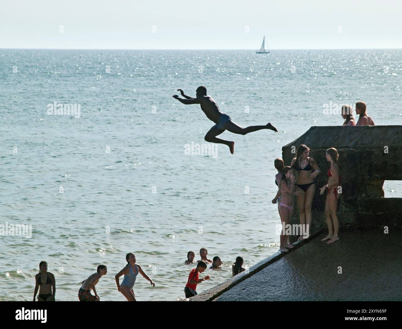 Sauter dans la mer par une chaude journée ensoleillée à Brighton, en Angleterre Banque D'Images