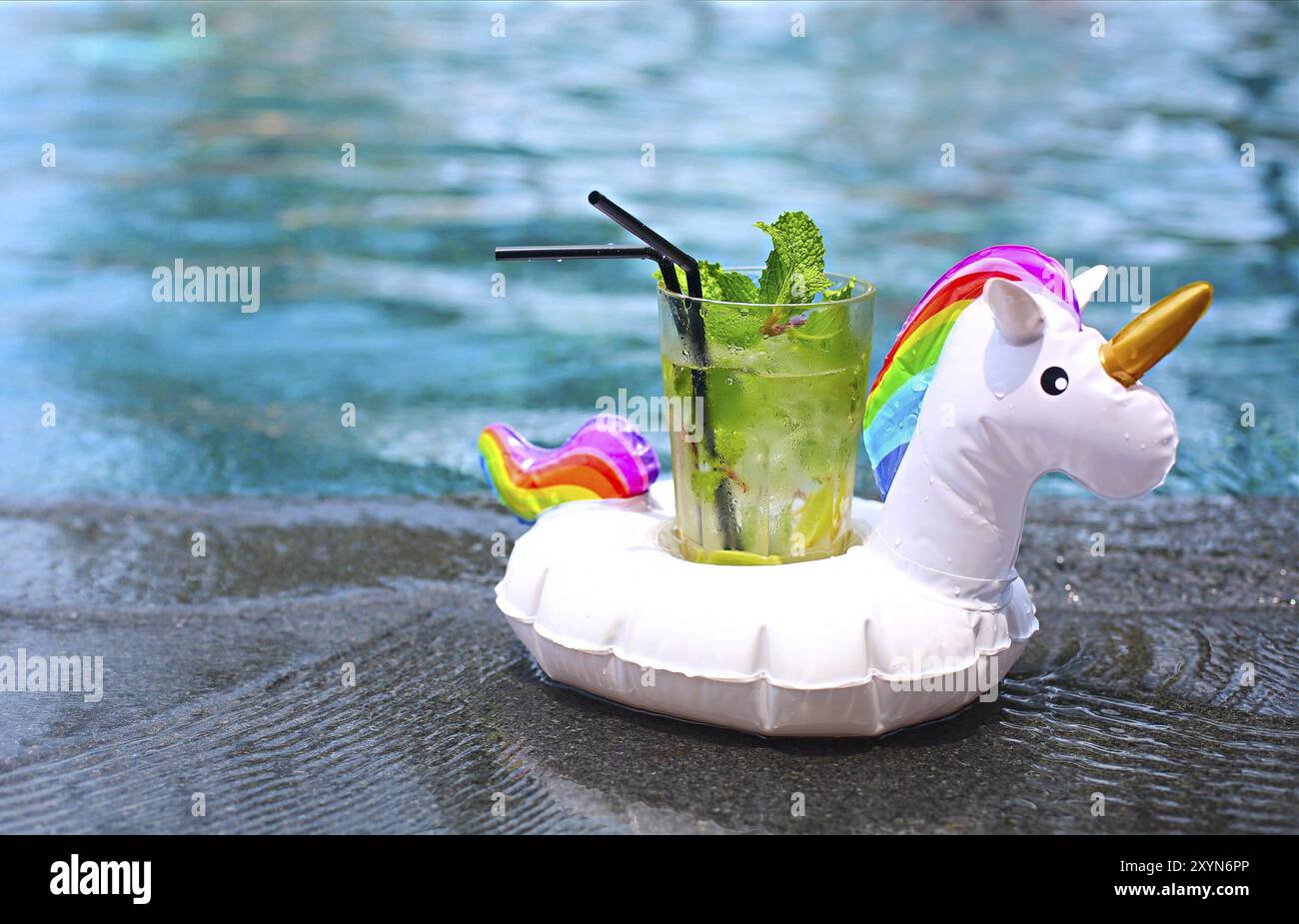 Mojito cocktail au bord d'une piscine gonflable en licorne. Concept de vacances de luxe. Piscine extérieure background Banque D'Images