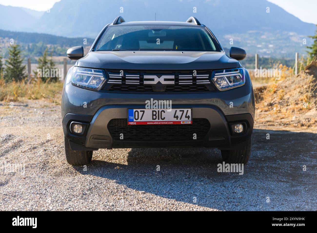 Kalkan, Turquie - 13 août 2024 : 2024 Dacia Duster vue en gros plan. Véhicule tout-terrain gris moderne se dresse sur le bord de la route près de la route de montagne sur un su Banque D'Images