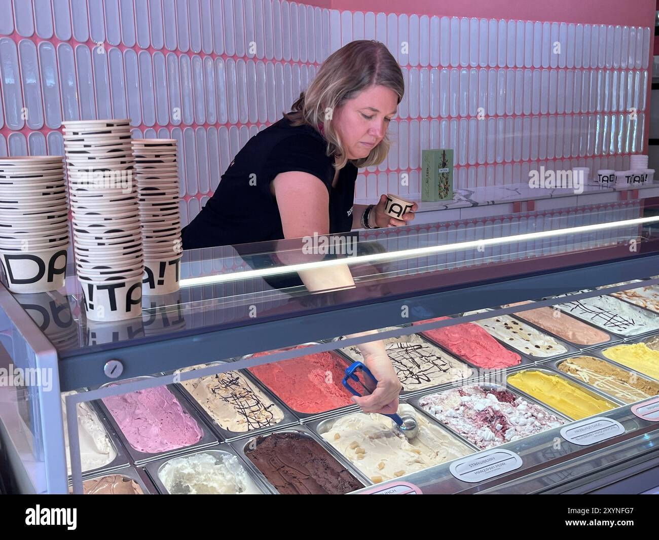 Kapstadt, Afrique du Sud. 30 août 2024. Originaire de Hambourg, Lena Sönnichsen (45) se tient dans son magasin de crème glacée. La femme de Blankenese a ouvert un glacier dans la métropole touristique sud-africaine du Cap, où des dizaines de milliers d’Allemands partent en vacances chaque année. Crédit : Kristin Palitza/dpa/Alamy Live News Banque D'Images