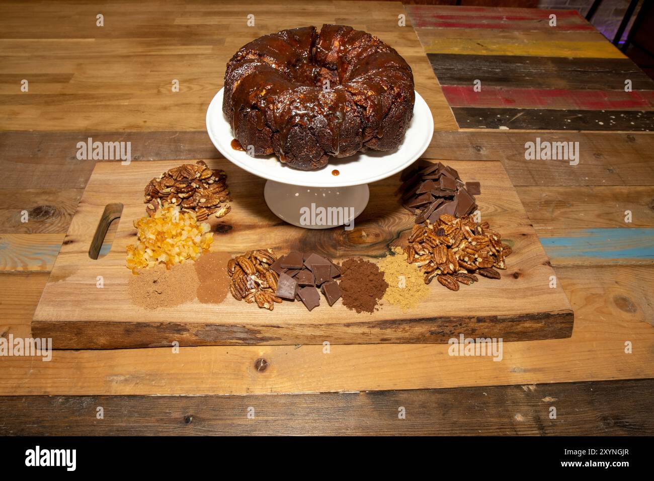 Un délicieux pain de singe au chocolat sur une table de cuisine en bois entouré par les ingrédients utilisés pour faire le pain Banque D'Images