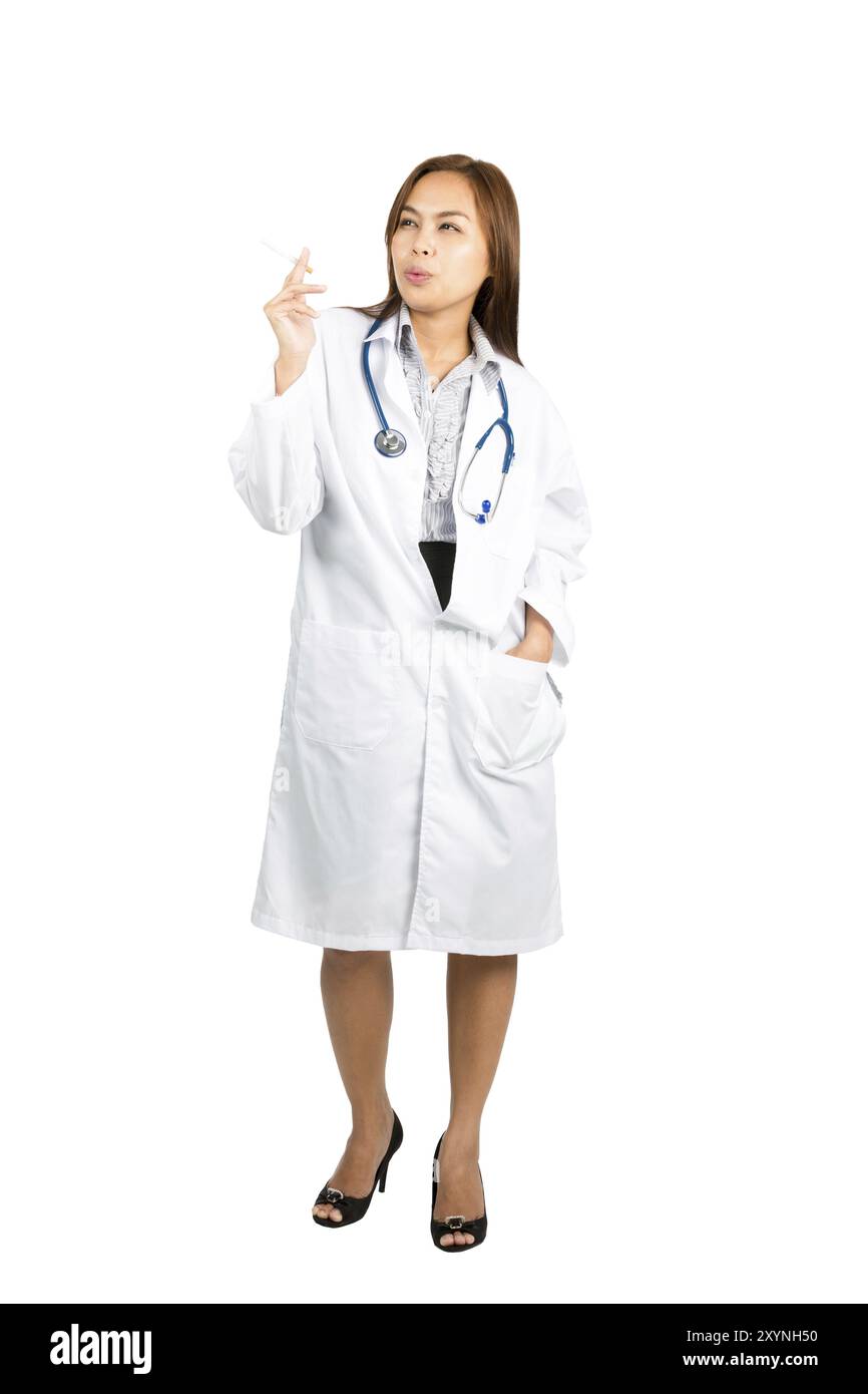 Une femme médecin asiatique regardant loin expirant, profitant de fumer une cigarette, montrant un plaisir calme tout en affichant une habitude ironique malsaine. Plein Banque D'Images