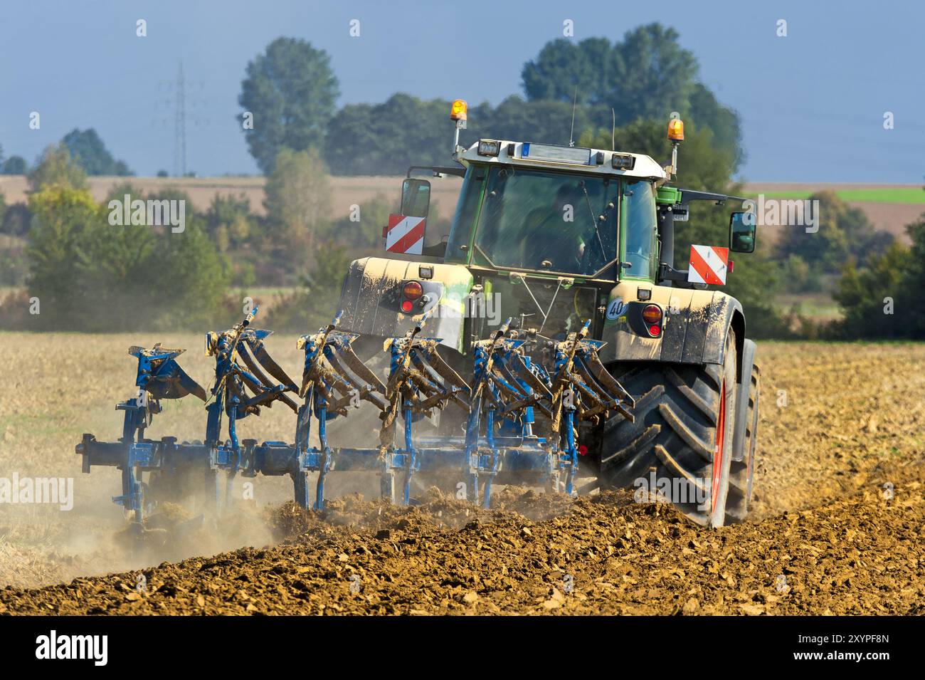 Agriculteur avec tracteur et charrue dans son champ Banque D'Images