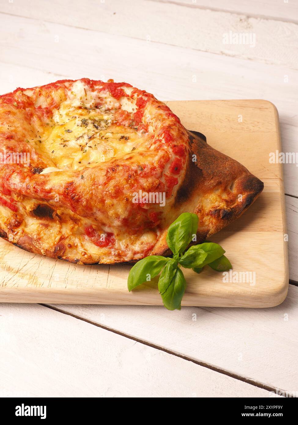 Calzone pizza savoureuse sur une planche à découper en bois Banque D'Images