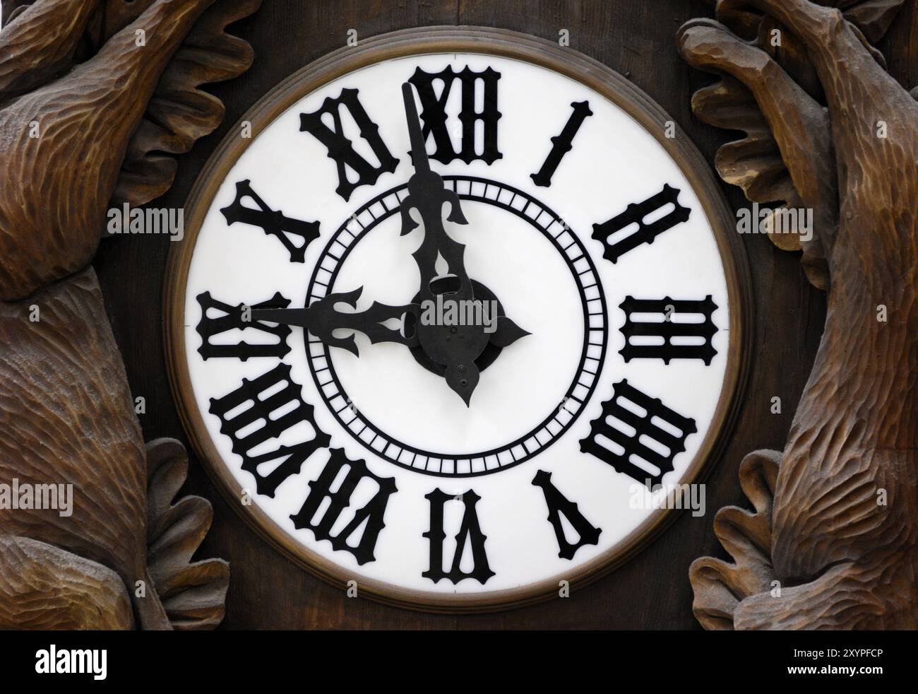 Ancienne horloge murale avec ornement décoratif sculpté dans le bois montrant neuf Banque D'Images