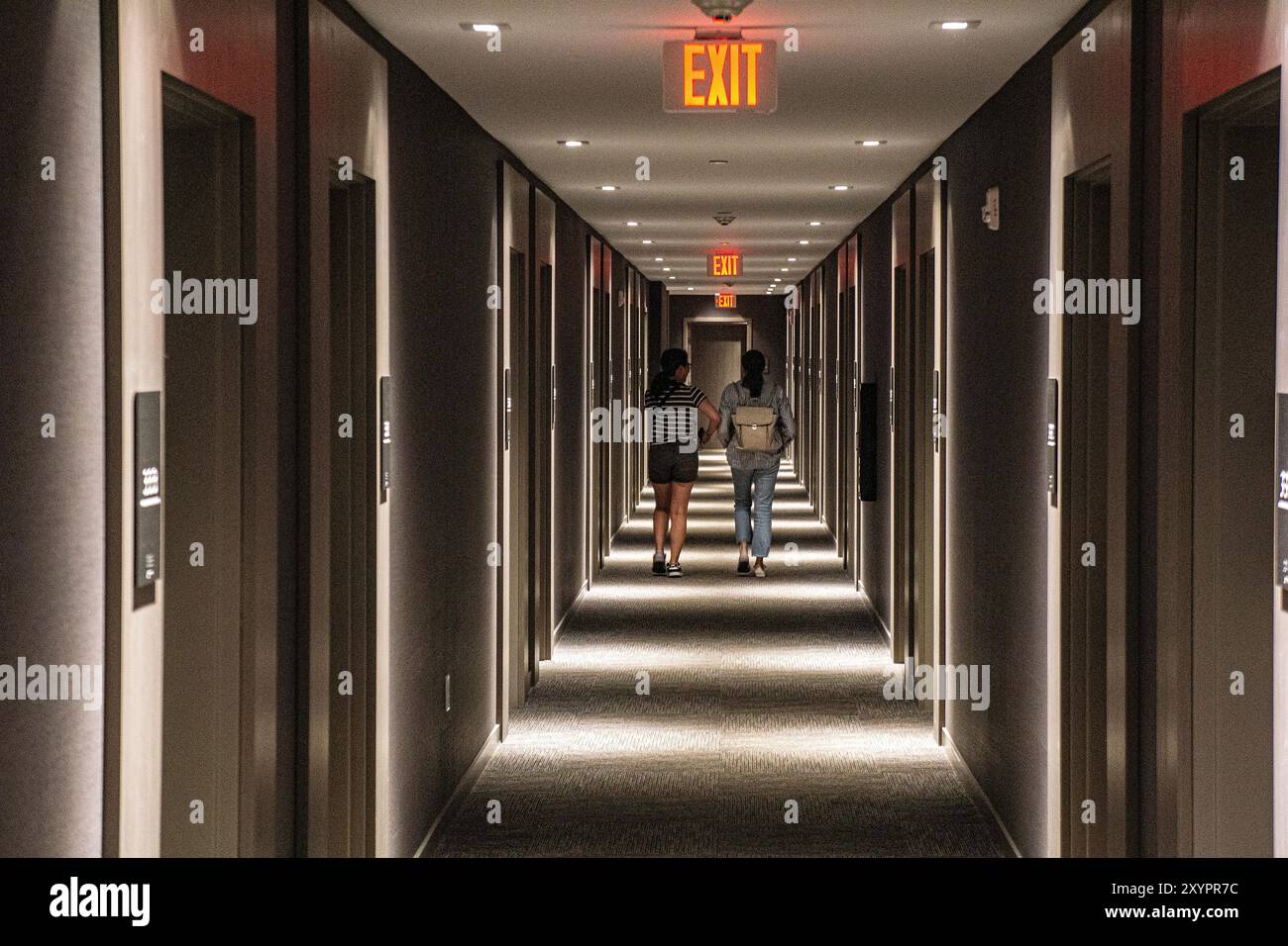 Vue arrière de deux personnes marchant dans le couloir de l'hôtel, perspective décroissante Banque D'Images