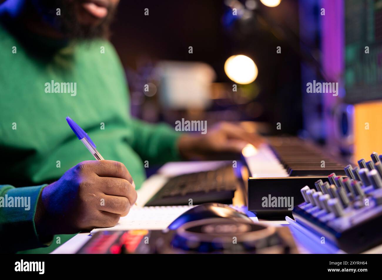 Auteur-compositeur prenant des notes pour créer de nouvelles pistes pour un album dans son home studio, écrivant des paroles et des éléments harmoniques avant d'enregistrer sa chanson et montage sur logiciel, ingénierie acoustique. Banque D'Images