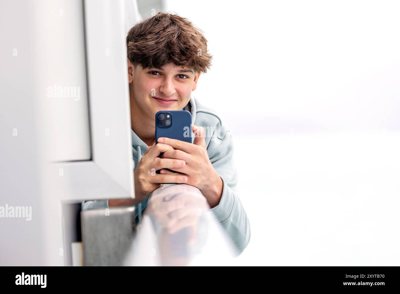 Photo d'un adolescent tenant un téléphone portable et regardant la caméra - Alaska, USA Banque D'Images