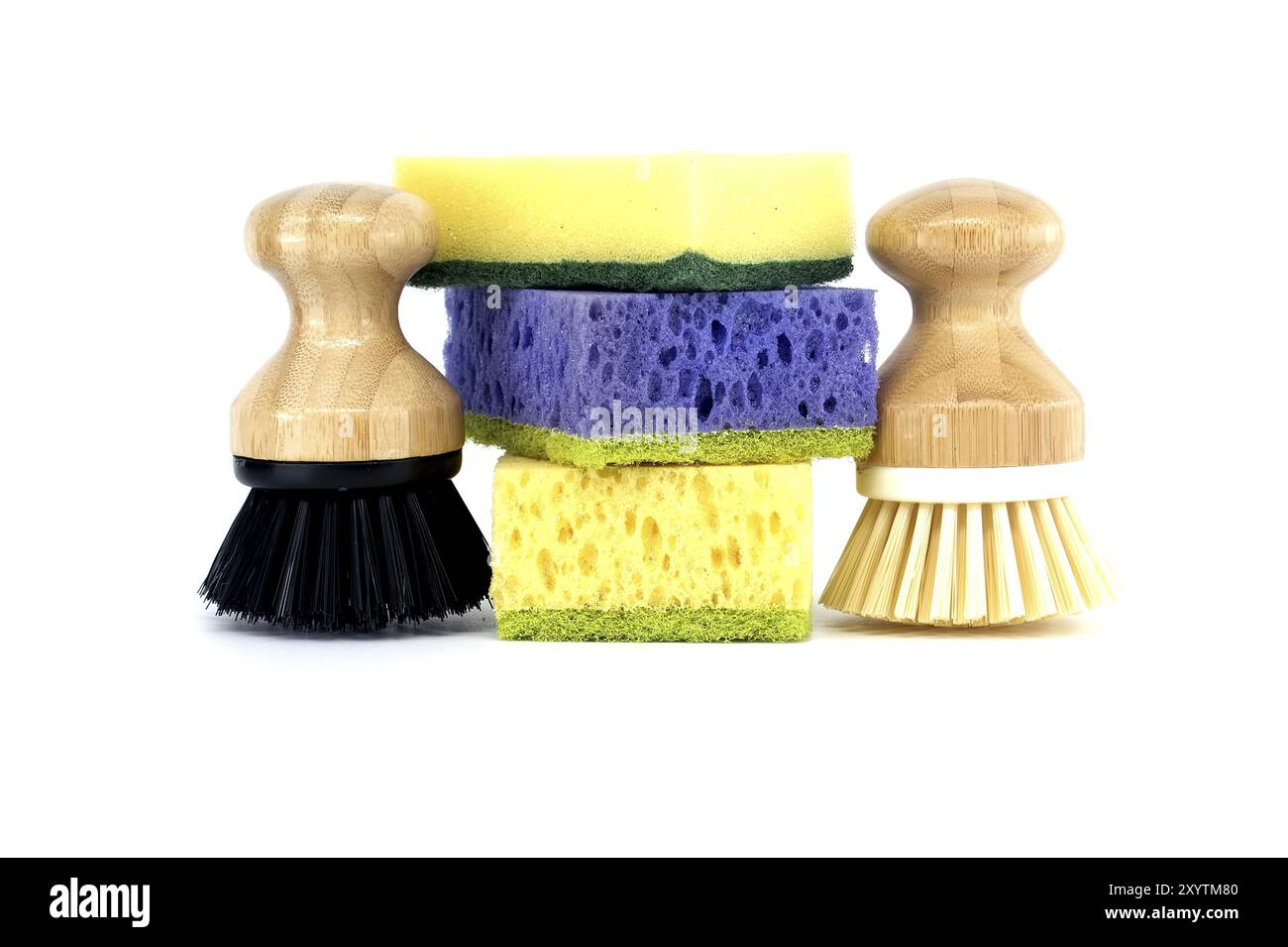 Trois éponges, chacune d'une couleur différente violet, jaune et bleu et deux brosses avec des poignées en bois isolées sur fond blanc, outils de nettoyage Banque D'Images