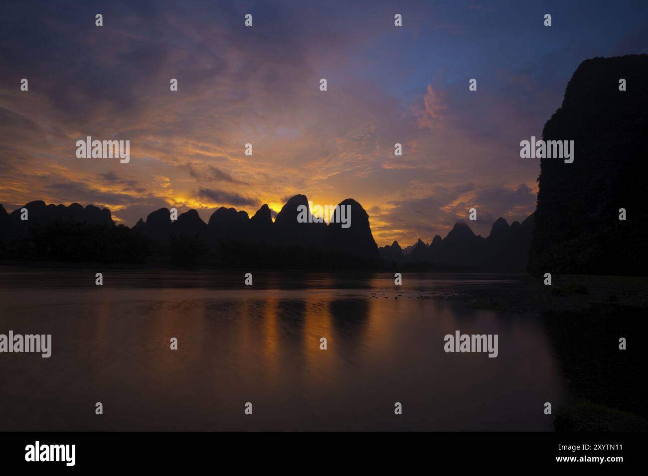 Une belle scène naturelle d'une rivière floue en mouvement et des formations karstiques au coucher du soleil à Xingping, Chine, Asie Banque D'Images