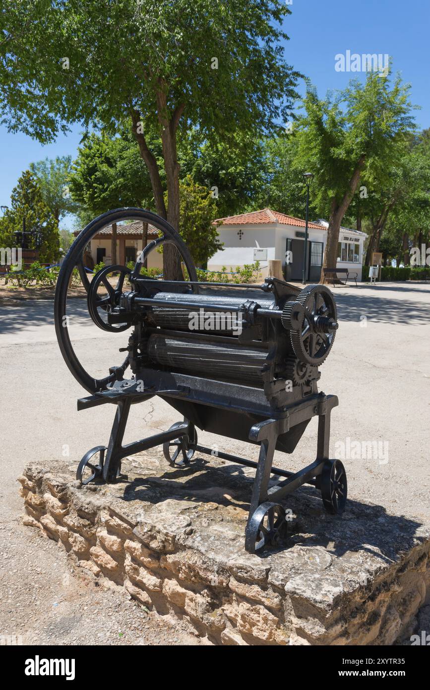 Historische Metallmaschine mit grossen Raedern auf einem steinigen Untergrund im Freien, umgeben von Baeumen, antike Waeschemangel, Eremitage und Muse Banque D'Images