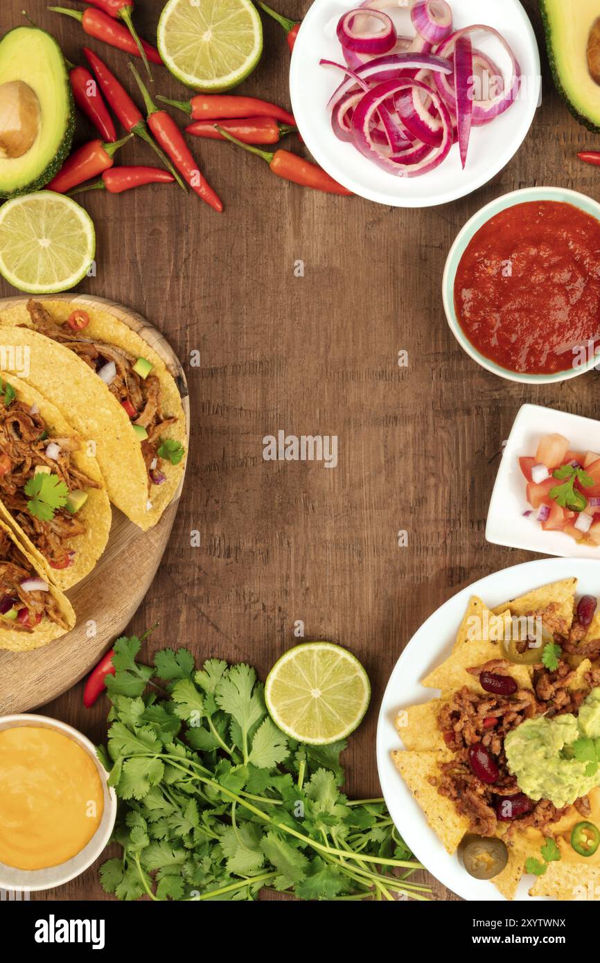 Une photo prise à la verticale d'un ssortment de beaucoup de différents aliments mexicains, y compris des tacos, guacamole, pico de gallo, nachos et autres, avec copie espace Banque D'Images