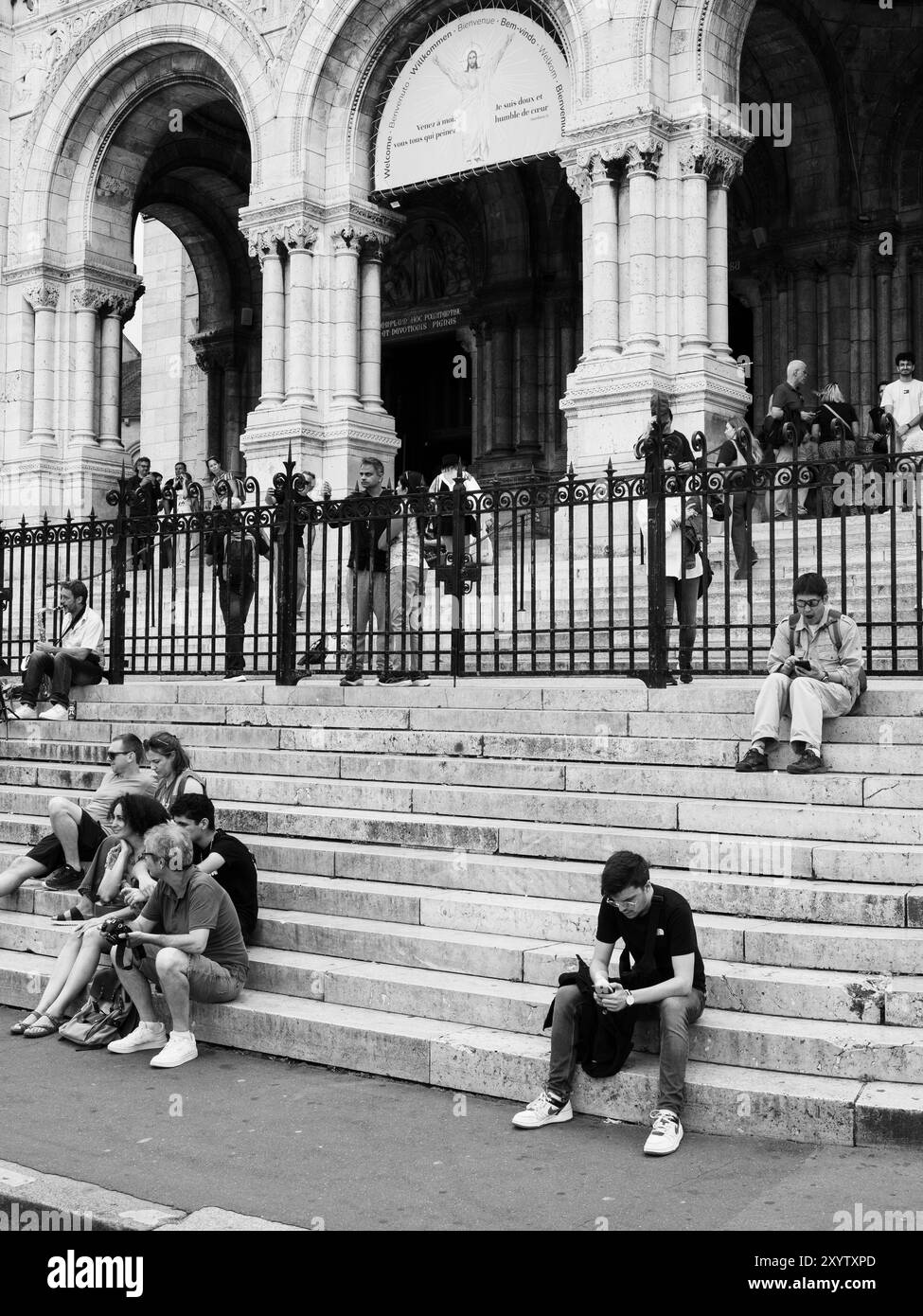 Noir et blanc, touristes reposant sur les marches du Sacré coeur, Montmartre, Paris, France, Europe, UE. Banque D'Images