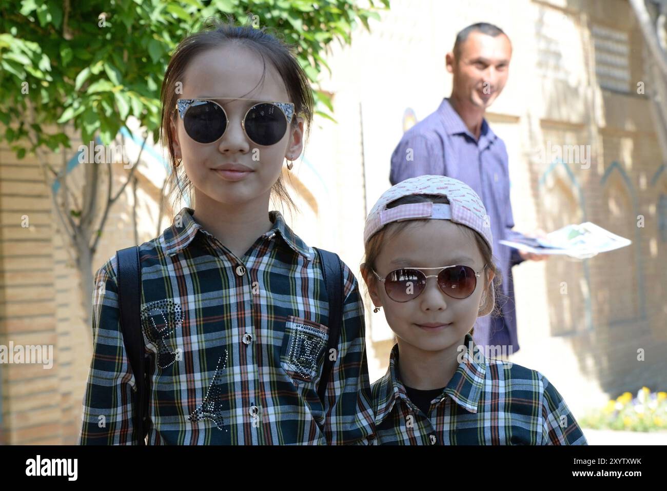 Sœur et frère en lunettes de soleil, avec leur père regardant dans le fond Banque D'Images