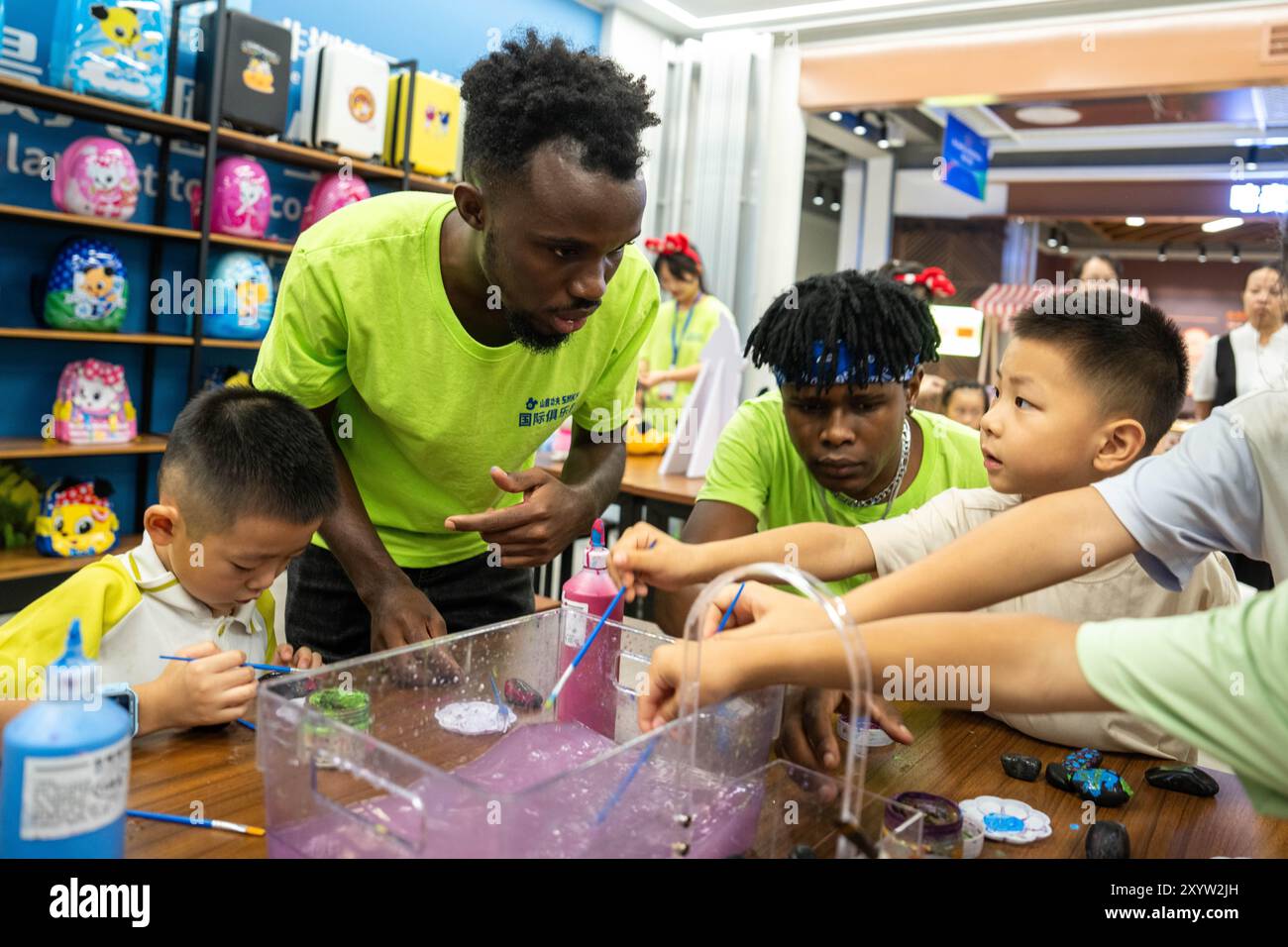 (240831) -- CHANGSHA, 31 août 2024 (Xinhua) -- des volontaires présentent la peinture sur pierre aux enfants lors d'une session pratique au pavillon du Malawi d'une salle d'exposition permanente du Parc de démonstration de l'innovation pour la promotion de la coopération économique et commerciale Chine-Afrique à Changsha, dans la province du Hunan, au centre de la Chine, le 30 août 2024. Diverses activités de promotion de la communication des jeunes entre la Chine et l'Afrique ont été organisées ici pendant les vacances d'été. Avec l’aide de volontaires africains des universités locales, les étudiants chinois ont pu ressentir le charme de la culture africaine en apprenant le tra Banque D'Images