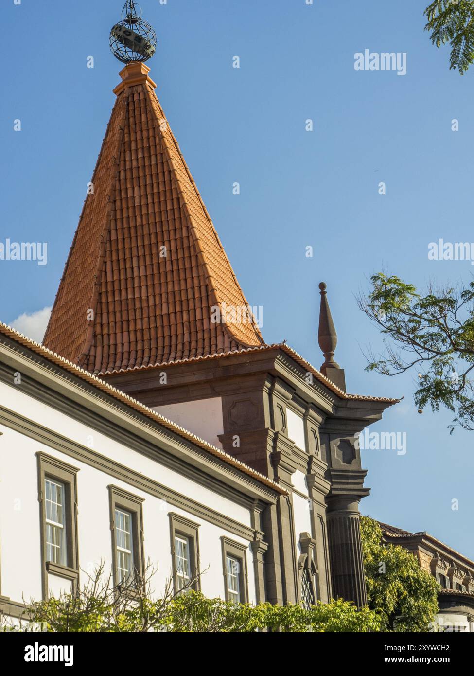 Vue détaillée d'un bâtiment historique avec un toit rouge pointu sous un ciel dégagé, Funchal, madère, portugal Banque D'Images