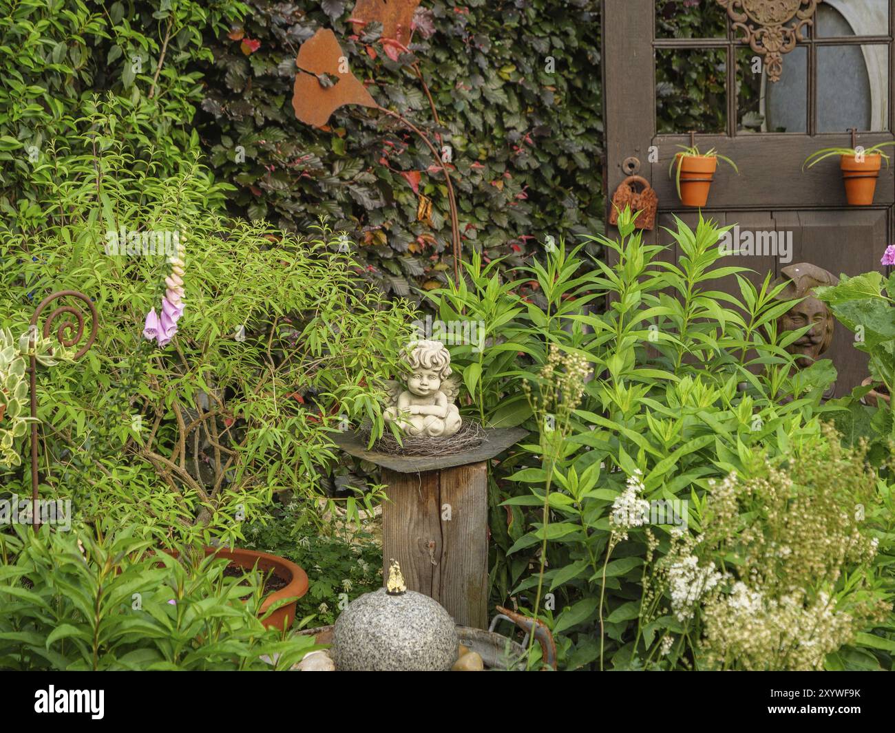 Jardin merveilleusement décoré avec une petite statuette, des plantes vertes et des figures artistiques découpées au laser en arrière-plan, borken, muensterland, allemagne Banque D'Images