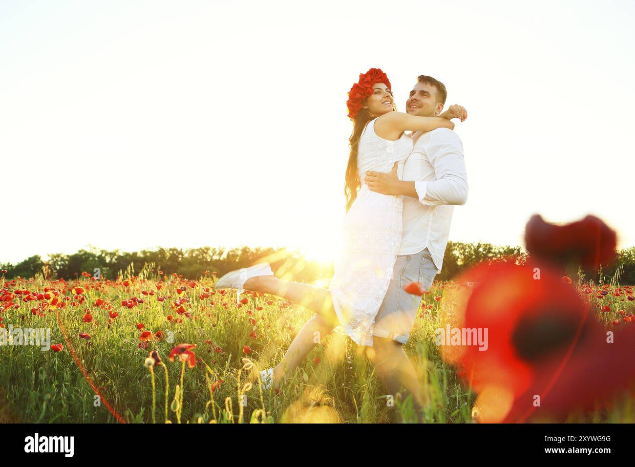 Couple in love hugging ensemble dans la nature au champ de coquelicots Banque D'Images Couple in love hugging ensemble dans la nature au champ de coquelicots Banque D'Images