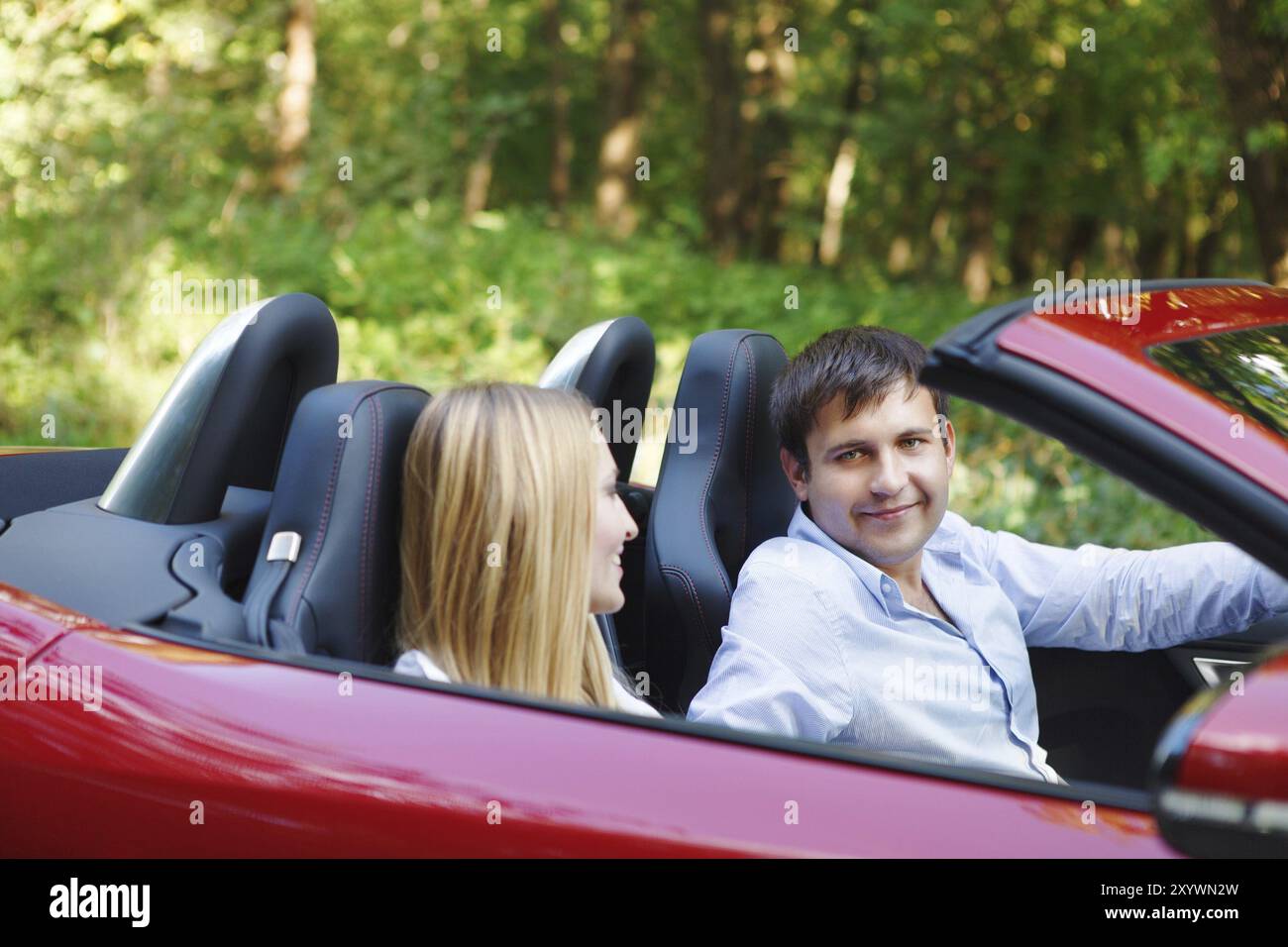 Heureux couple red cabriolet dans une journée ensoleillée Banque D'Images