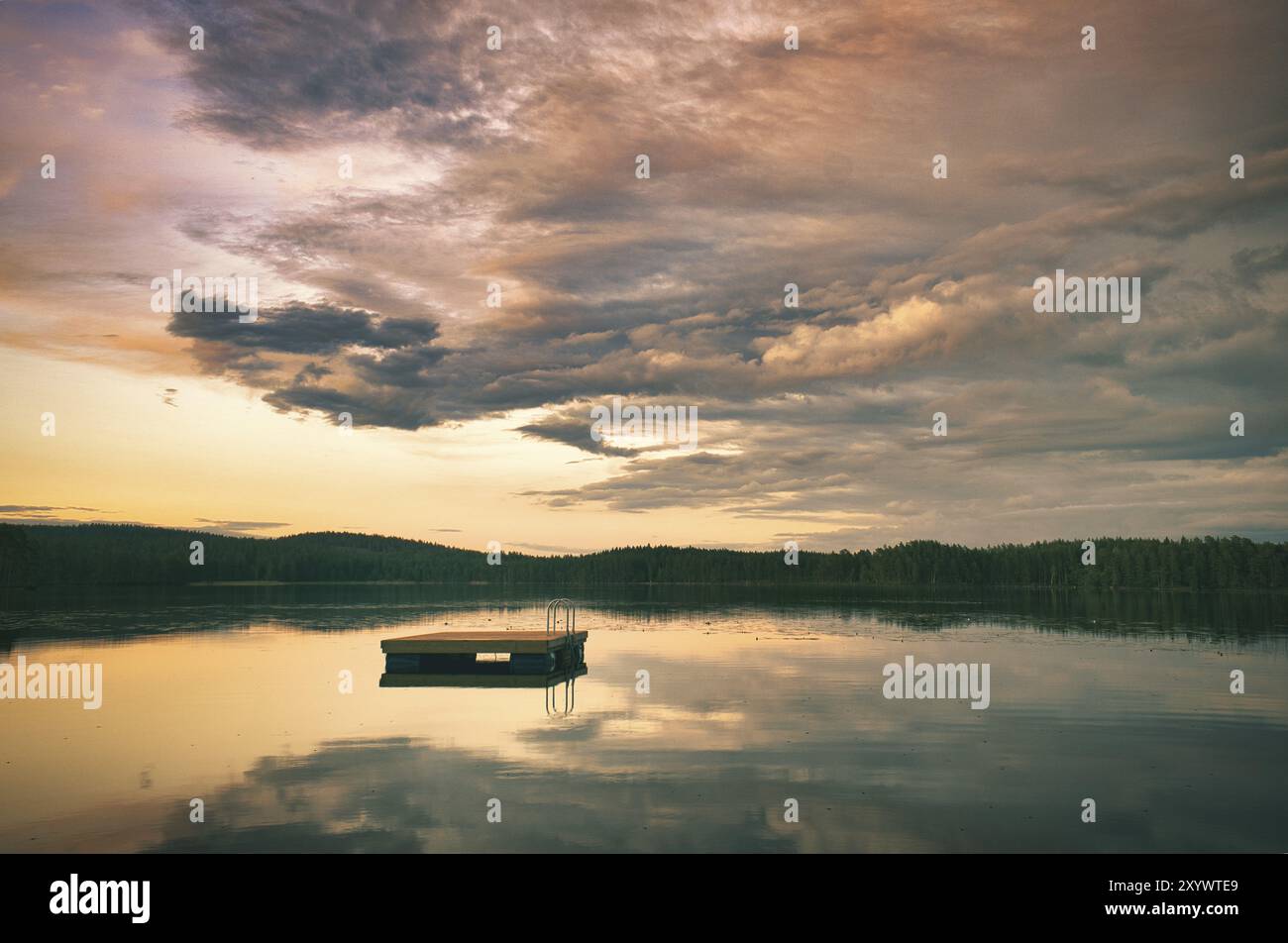 Île de baignade en Suède sur un lac au coucher du soleil. Nuages réfléchis dans l'eau. Natation plaisir en vacances avec loisirs en Scandinavie Banque D'Images