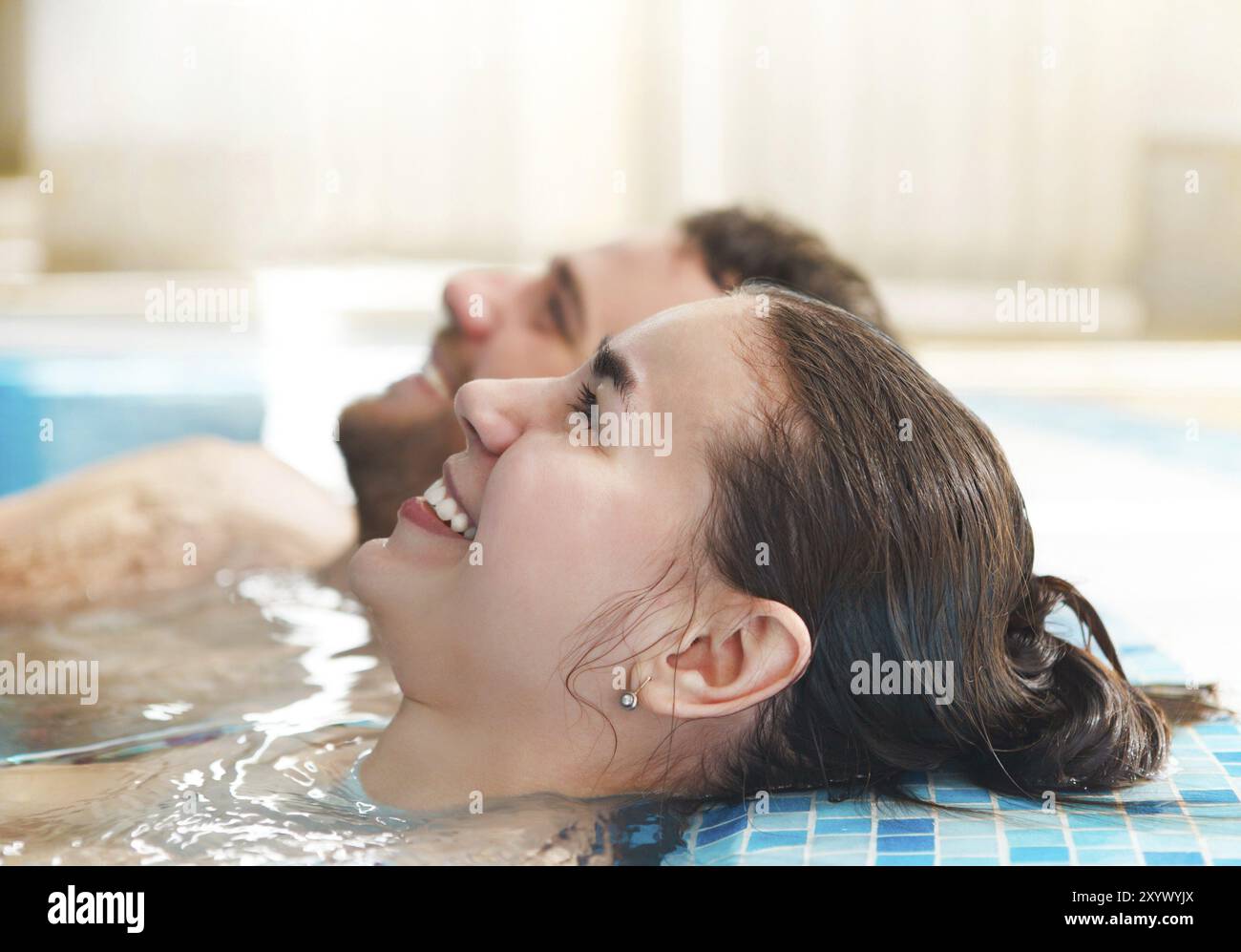 Jeune couple heureux de vous détendre dans l'eau dans un spa resort Banque D'Images