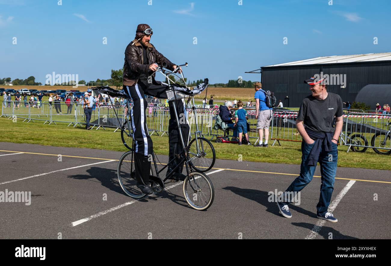 Musée national de l'aviation, East Lothian, Écosse, Royaume-Uni, 31 août 2024. 360 Fest : une variété de spectacles et d'activités sont proposés pour les familles aujourd'hui au Musée national de l'aviation sur une belle journée ensoleillée d'été. Sur la photo : Ian Fraser de Think Circus divertit les gens qui roulent sur un vélo très inhabituel tout en portant des échasses crédit : Sally Anderson/Alamy Live News Banque D'Images