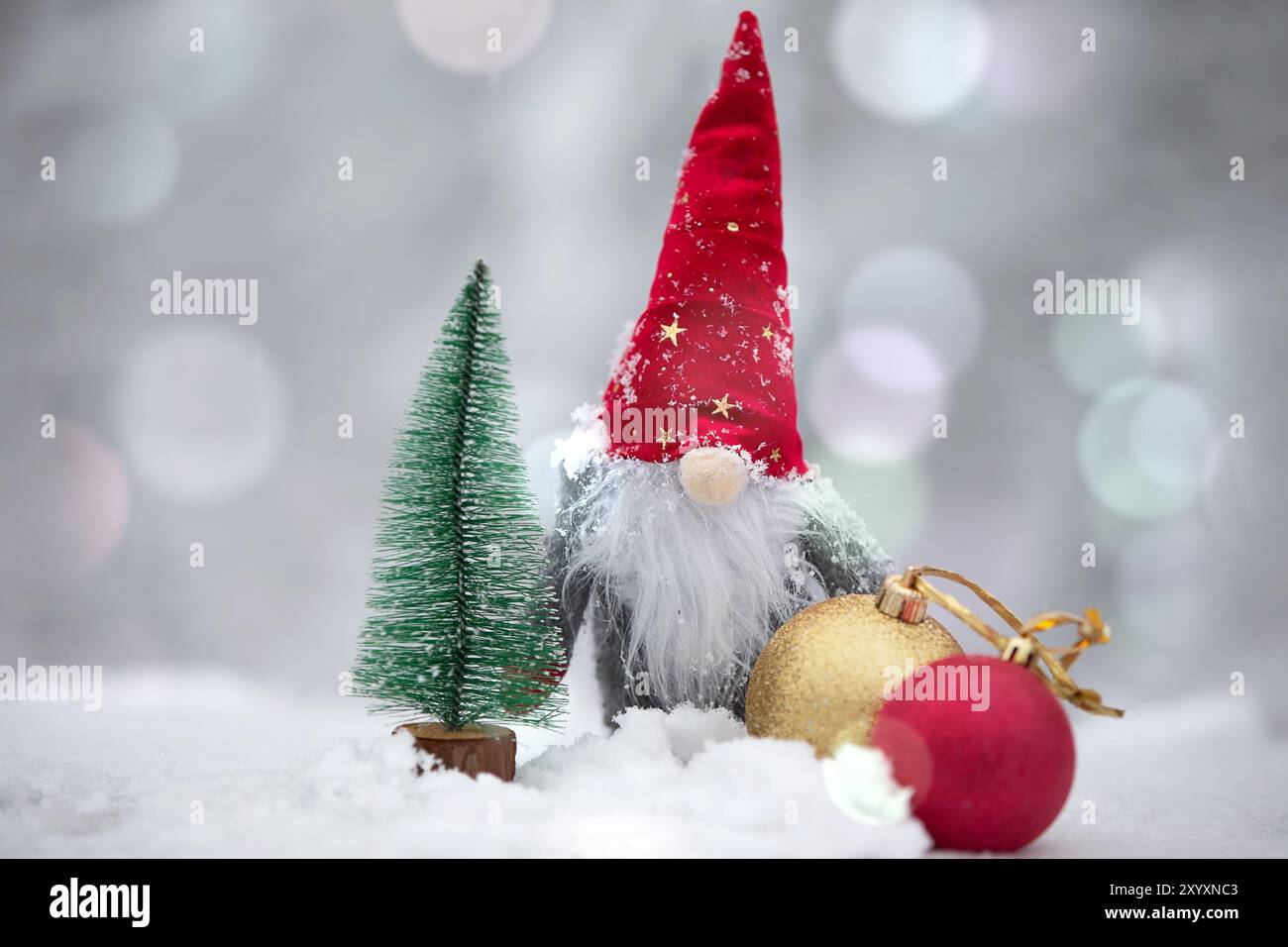 Une carte de Noël. Mignon nain dans un chapeau rouge sur un fond d'hiver. Banque D'Images