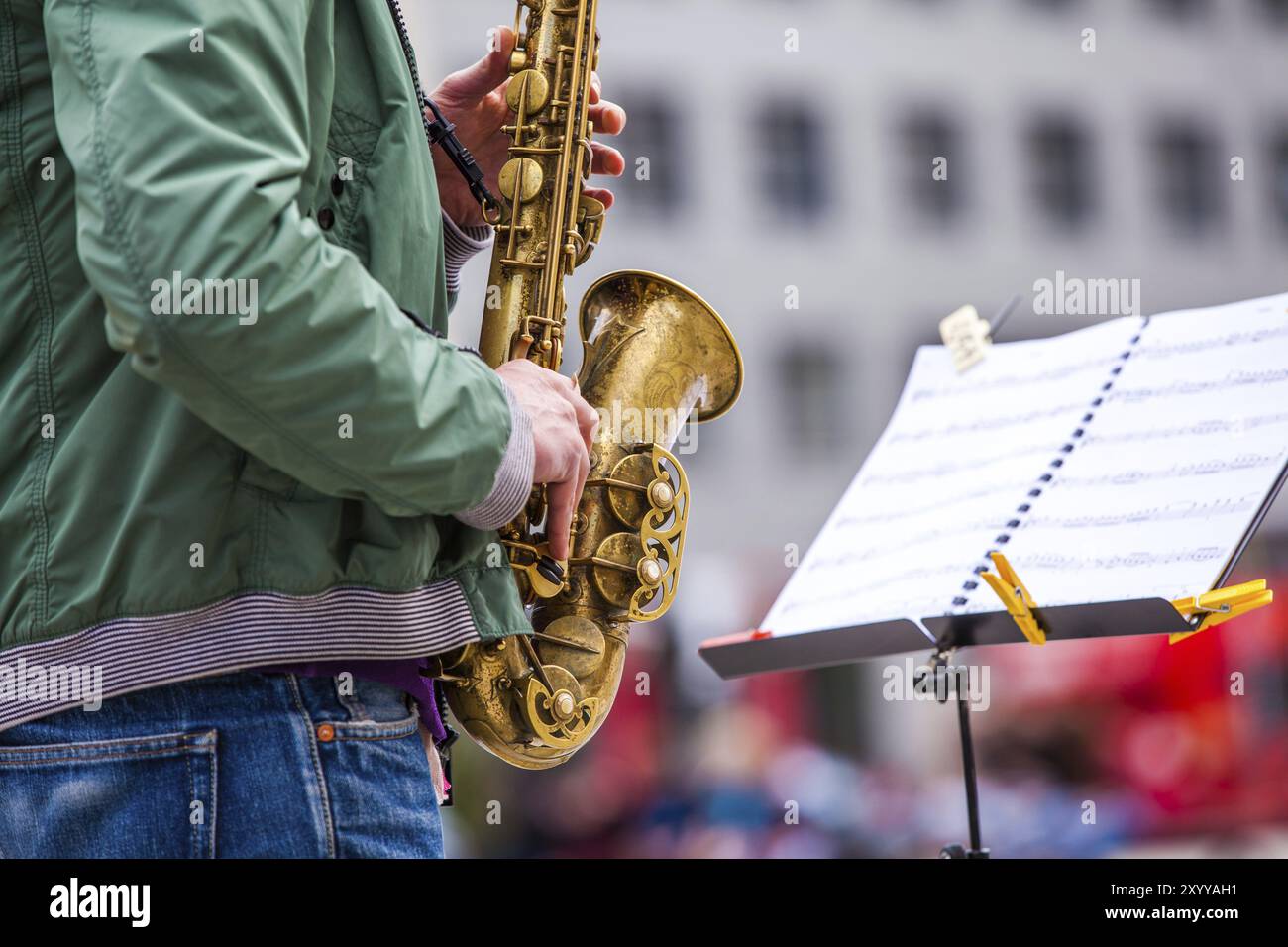 Gros plan d'un musicien de rue jouant du saxophone et d'un pupitre à musique Banque D'Images