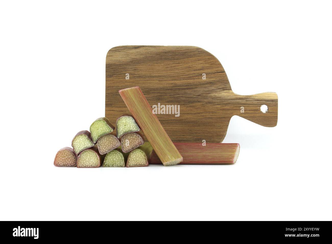 Des tiges de rhubarbe de couleurs variables du vert pâle au rouge profond devant une planche à découper en bois isolée sur fond blanc, illustrent une recette pour un Banque D'Images