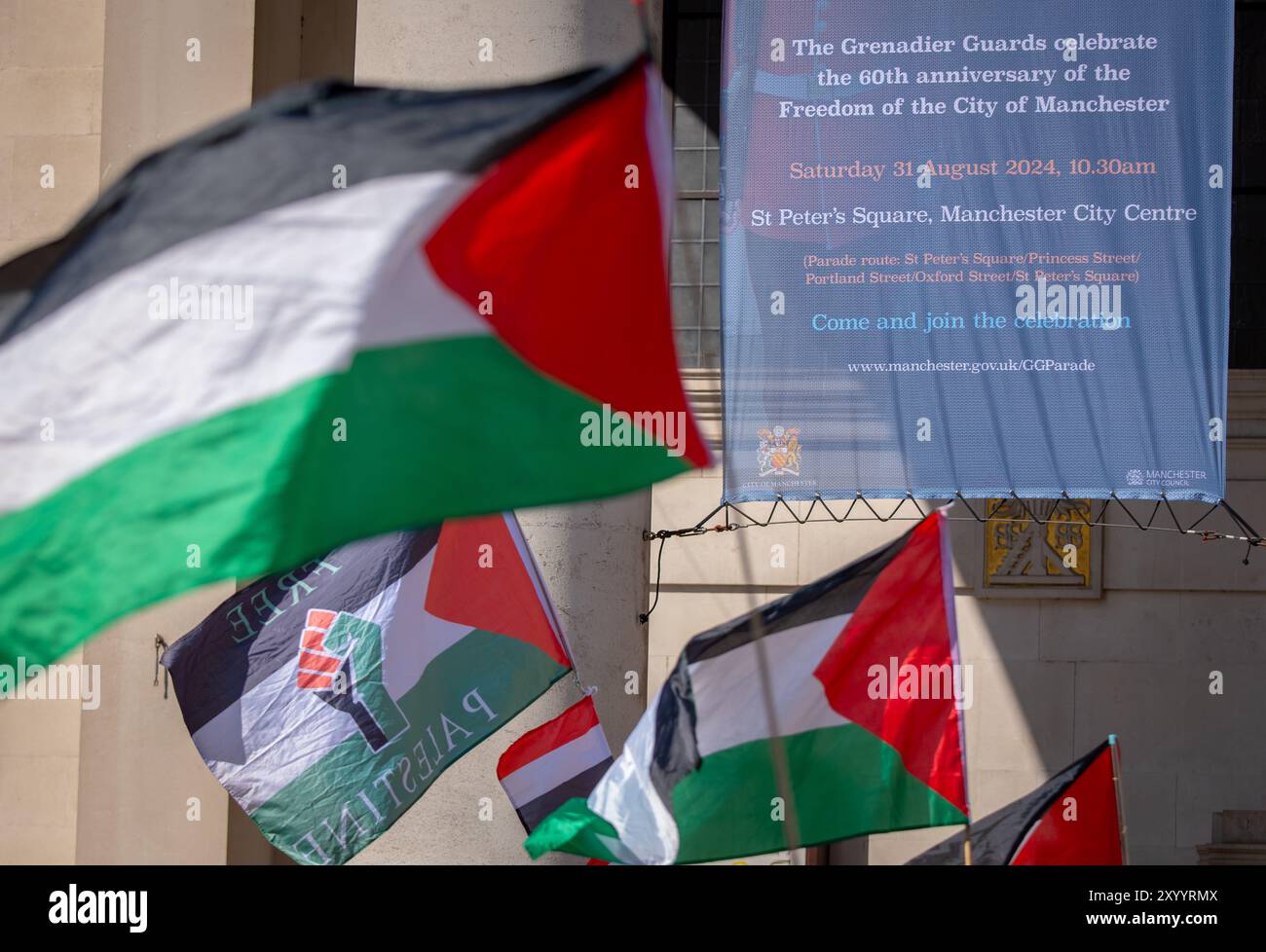 Manchester, Royaume-Uni. 31 août 2024. Drapeaux palestiniens devant une bannière célébrant le 60e anniversaire de la libération de la ville de Manchester par les gardes Grenadiers. Manifestants palestiniens à Manchester lors de leur 48ème week-end de protestation suite à l'attaque du Hamas le 7 octobre. Les manifestants ont défilé dans le centre de Manchester en commençant et en terminant à St Peter's Square. La marche s’est arrêtée au bâtiment d’assurance Axa, sur King Street, pour marquer leurs remerciements pour le désinvestissement de la société en Israël. Des bus et des tramways ont été retenus alors que la marche se déroulait sous escorte policière. Manchester Royaume-Uni. Banque D'Images