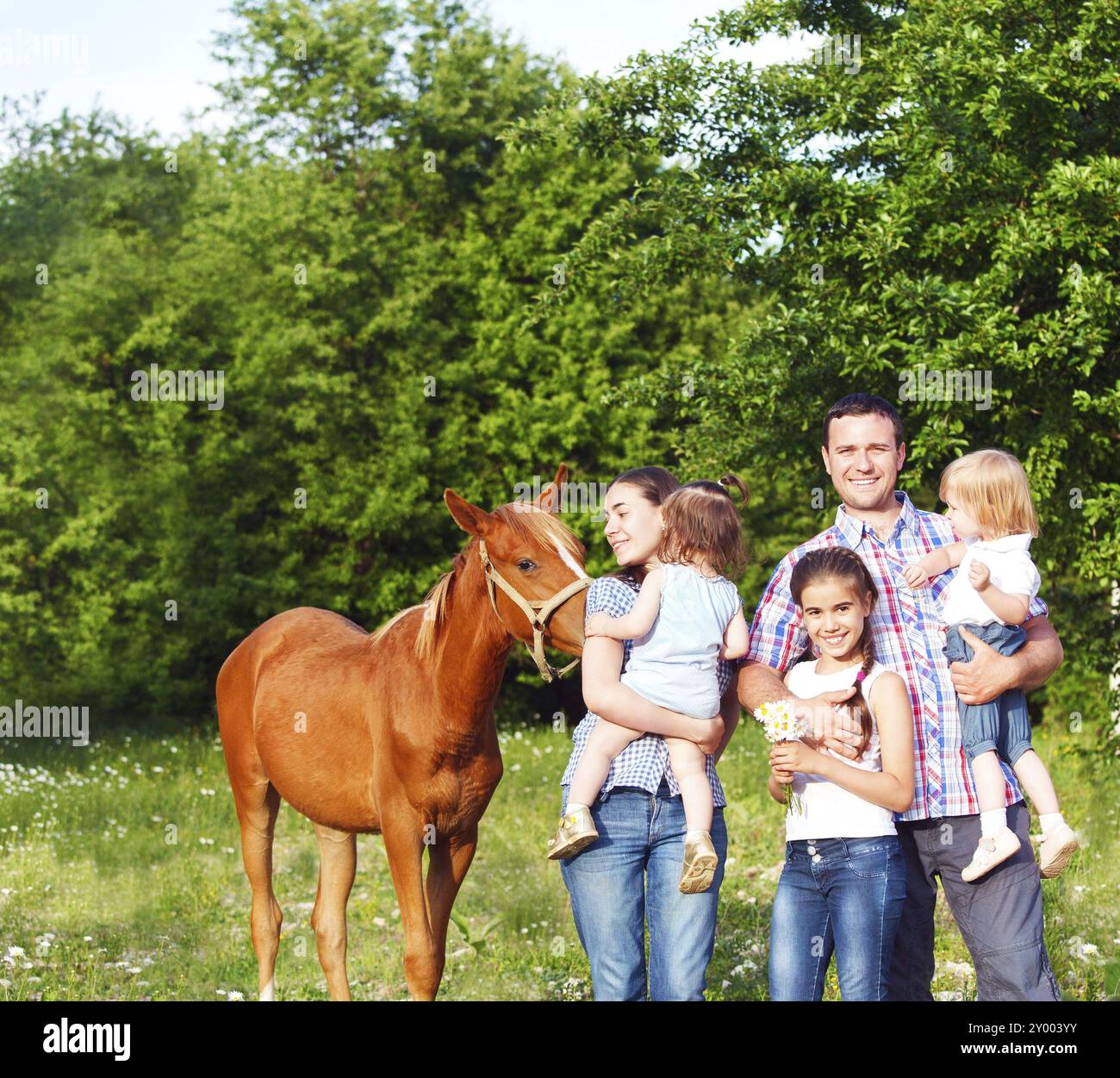 Heureux jeune famille avec quatre enfants et bébé cheval dans la forêt au printemps Banque D'Images