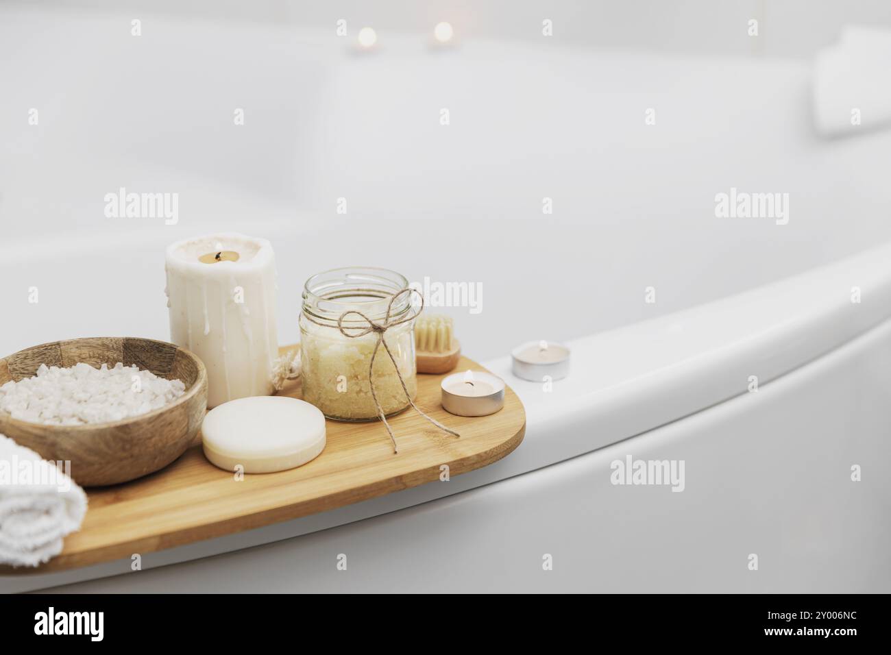 Préparation pour le soin spa de l'hôtel, la procédure de bain à la maison. Lavabo blanc dans la salle de bains, accessoires sur le plateau bougies allumées, savon, brosse à pied, serviette, Banque D'Images