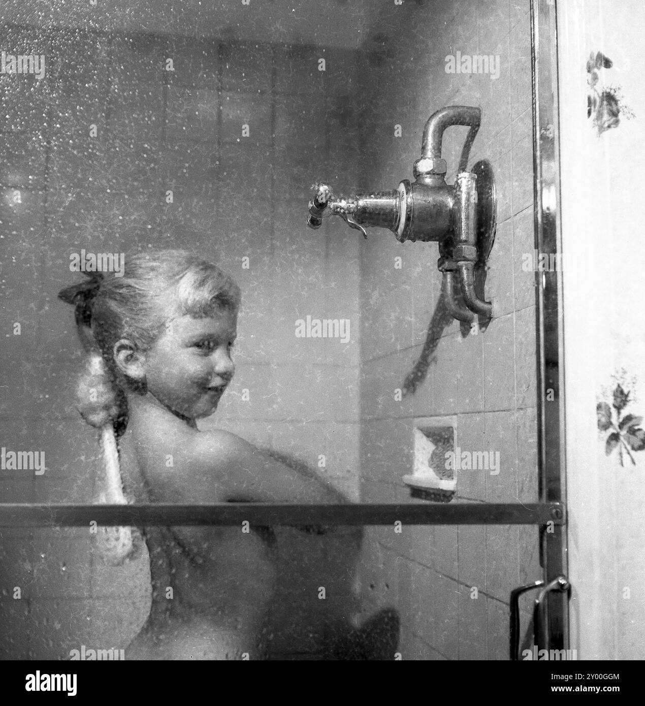 1991, historique, jeune fille profitant d'une nouvelle douche de puissance. Banque D'Images