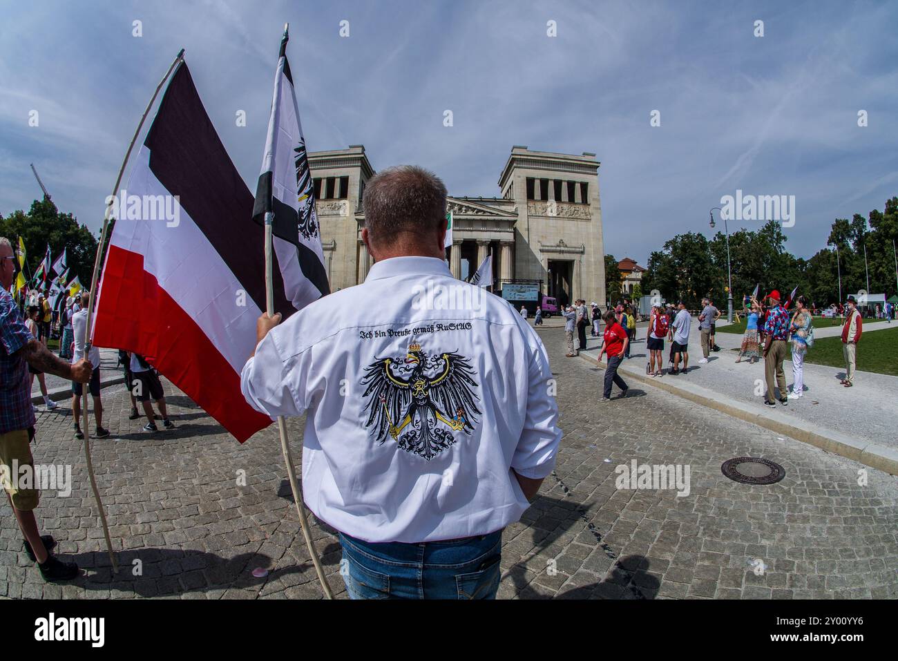 31 août 2024 : sous le nom de 'Grosser Treffen der 25 1 Bundesstaaten'', Reichsbuerger (ReichsbÃ¼rger, citoyens souverains, citoyens du Reich) s'est réuni sur la Koenigsplatz de Munich pour établir un réseau et nier la légitimité de la république allemande. Les Reichsbuerger ont été à l'origine banalisés et transformés en comédie dans les médias contre les avertissements de radicalisation par des experts jusqu'à ce qu'un raid à Georgesmund entraîne la mort d'un policier. L'affaire a également révélé Reichsbuerger dans la police et les structures étatiques mêmes dont ils nient la légitimité. À Munich, de nombreux Reichsbuerge connus Banque D'Images