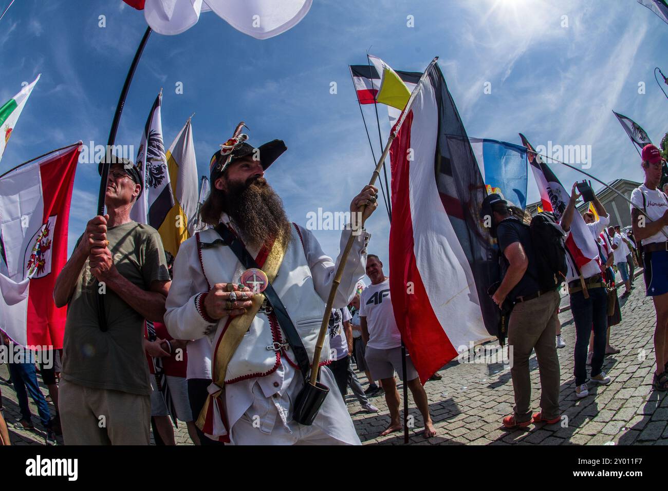 31 août 2024 : sous le nom de 'Grosser Treffen der 25 1 Bundesstaaten'', Reichsbuerger (ReichsbÃ¼rger, citoyens souverains, citoyens du Reich) s'est réuni sur la Koenigsplatz de Munich pour établir un réseau et nier la légitimité de la république allemande. Les Reichsbuerger ont été à l'origine banalisés et transformés en comédie dans les médias contre les avertissements de radicalisation par des experts jusqu'à ce qu'un raid à Georgesmund entraîne la mort d'un policier. L'affaire a également révélé Reichsbuerger dans la police et les structures étatiques mêmes dont ils nient la légitimité. À Munich, de nombreux Reichsbuerge connus Banque D'Images