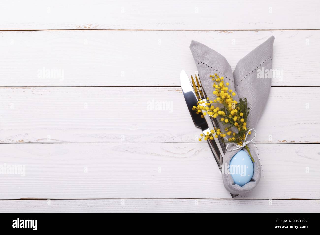 Table de Pâques avec oeuf bleu et mimosa. Fond de vacances avec espace de copie, pose à plat Banque D'Images