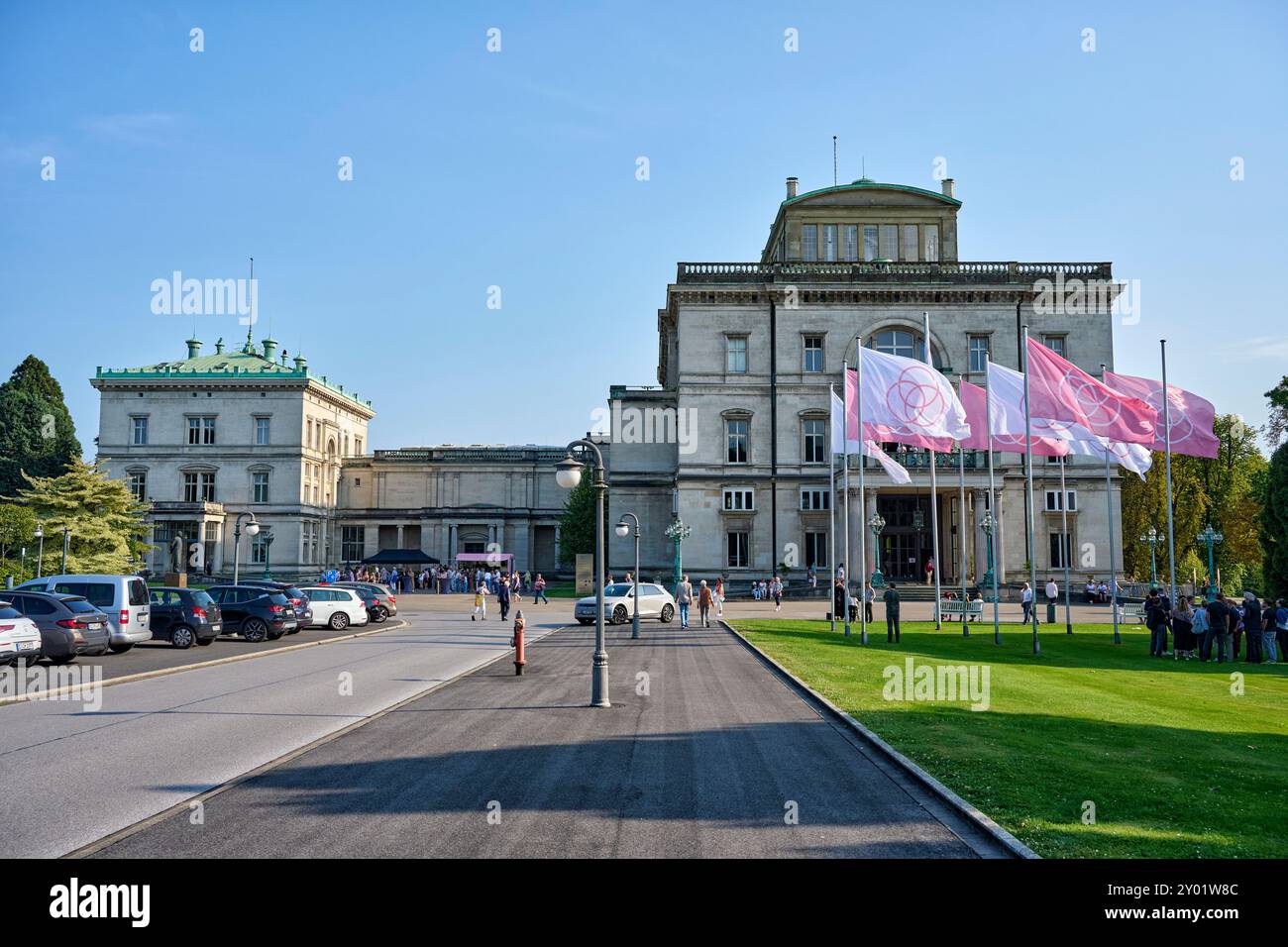 Die Villa Hügel beflagt mit rosa und weißen Flaggen mit dem Krupp Emblem. Es findet eine Veranstaltung statt die gut besucht ist. Die Flaggen wehen im Banque D'Images