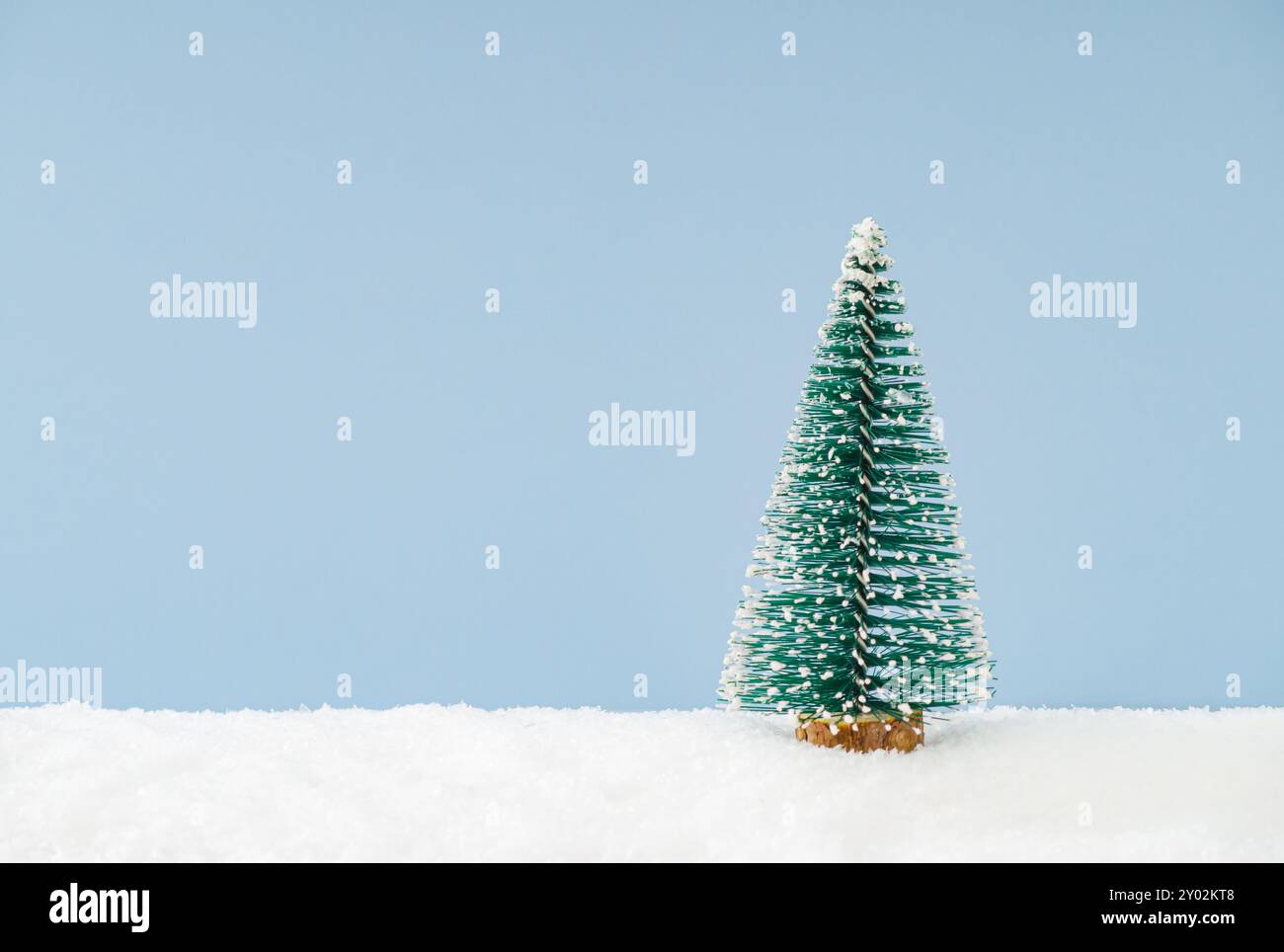 Scène de Noël faite avec arbre de Noël vert sur la neige sur fond bleu avec espace de copie. Concept minimal de Noël et de nouvel an. Banque D'Images