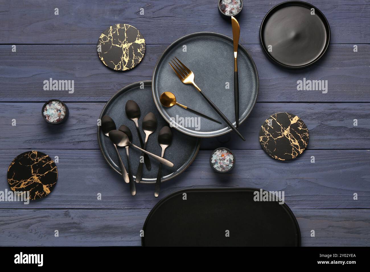 Nettoyez les assiettes avec un jeu de couverts et des dessous de verre sur une table en bois bleu Banque D'Images