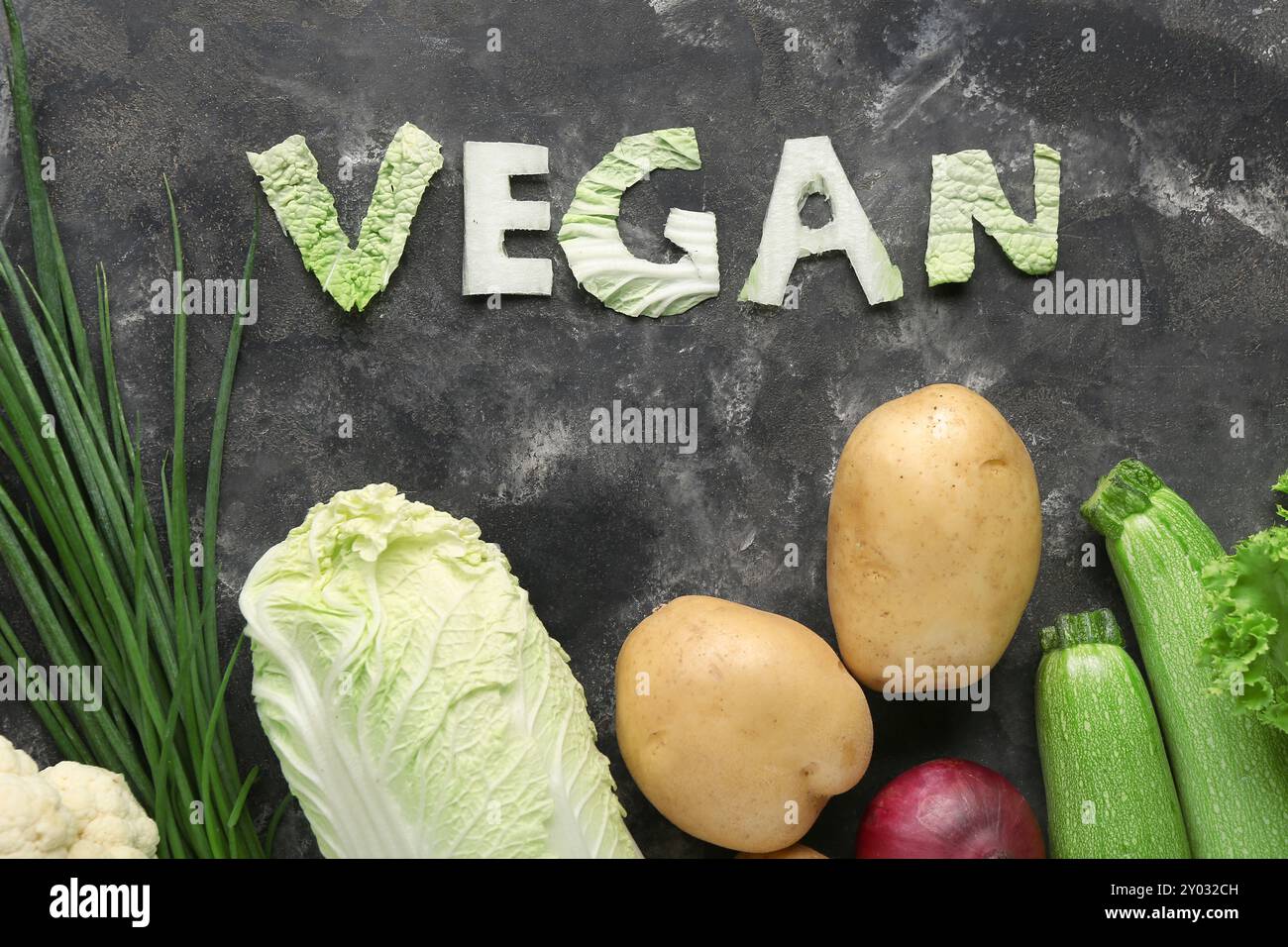 Mot VEGAN fait de chou et de différents légumes frais sur fond noir Banque D'Images