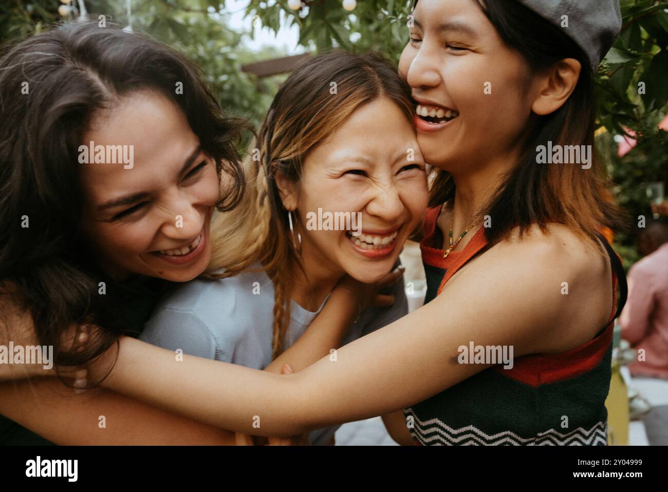 Amies féminines multiraciales joyeuses riant ensemble au dîner Banque D'Images